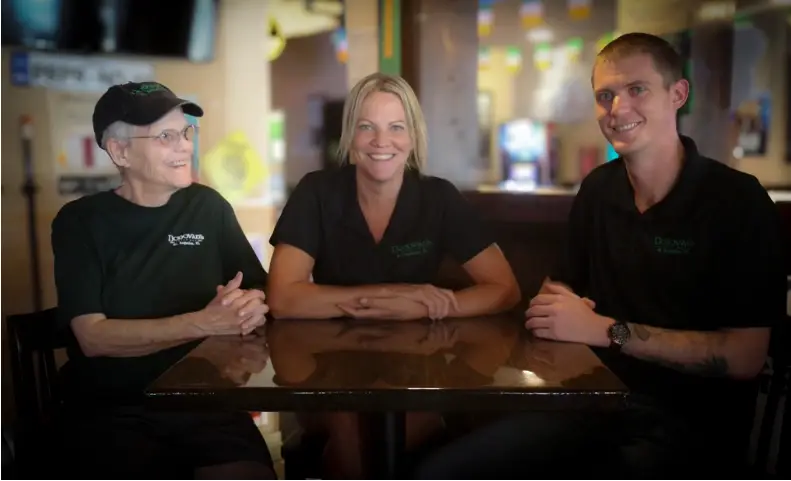 A son, mom, and grandma sitting at a table together.