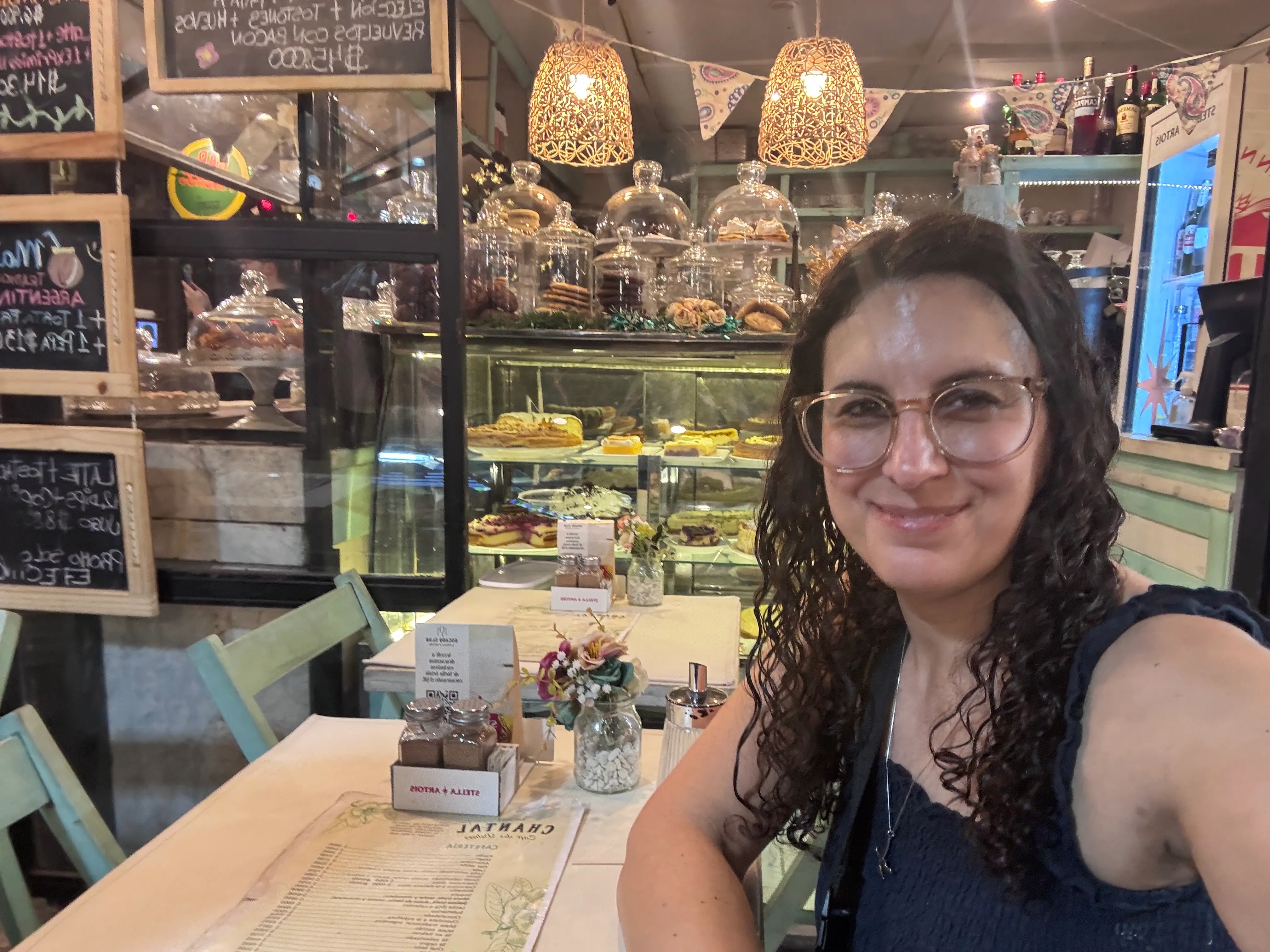 Woman smiling at empty table in bakery/restaurant