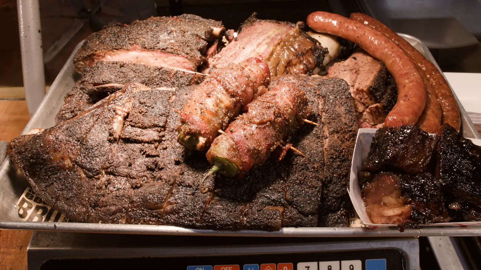 A plate of halal meat including sausages, Texas Twinkies, and dino ribs.