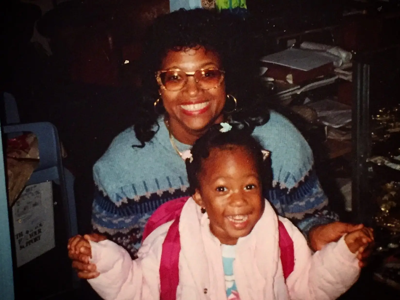 A child wearing a pink jacket with her mother.