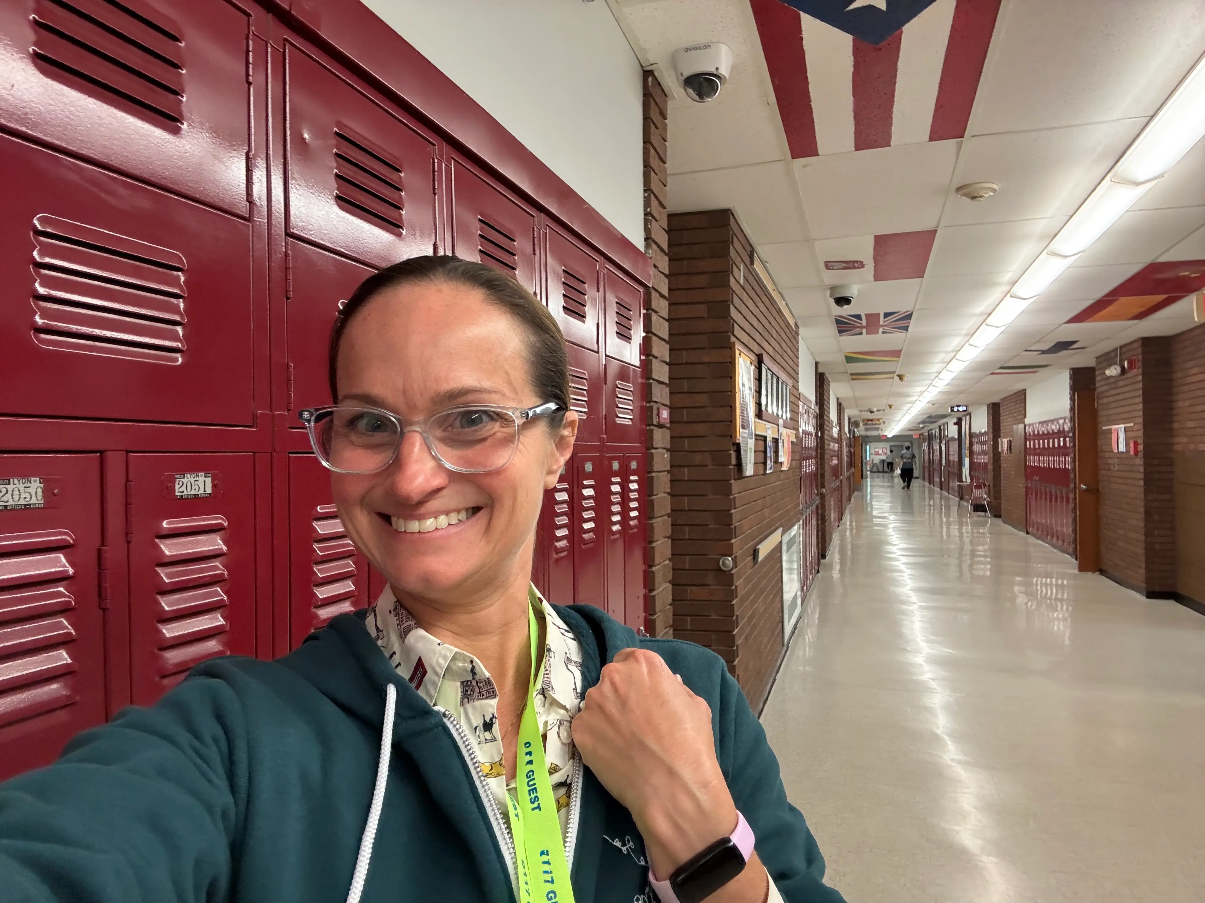 The author takes a selfie next to a row of lockers in a high school.