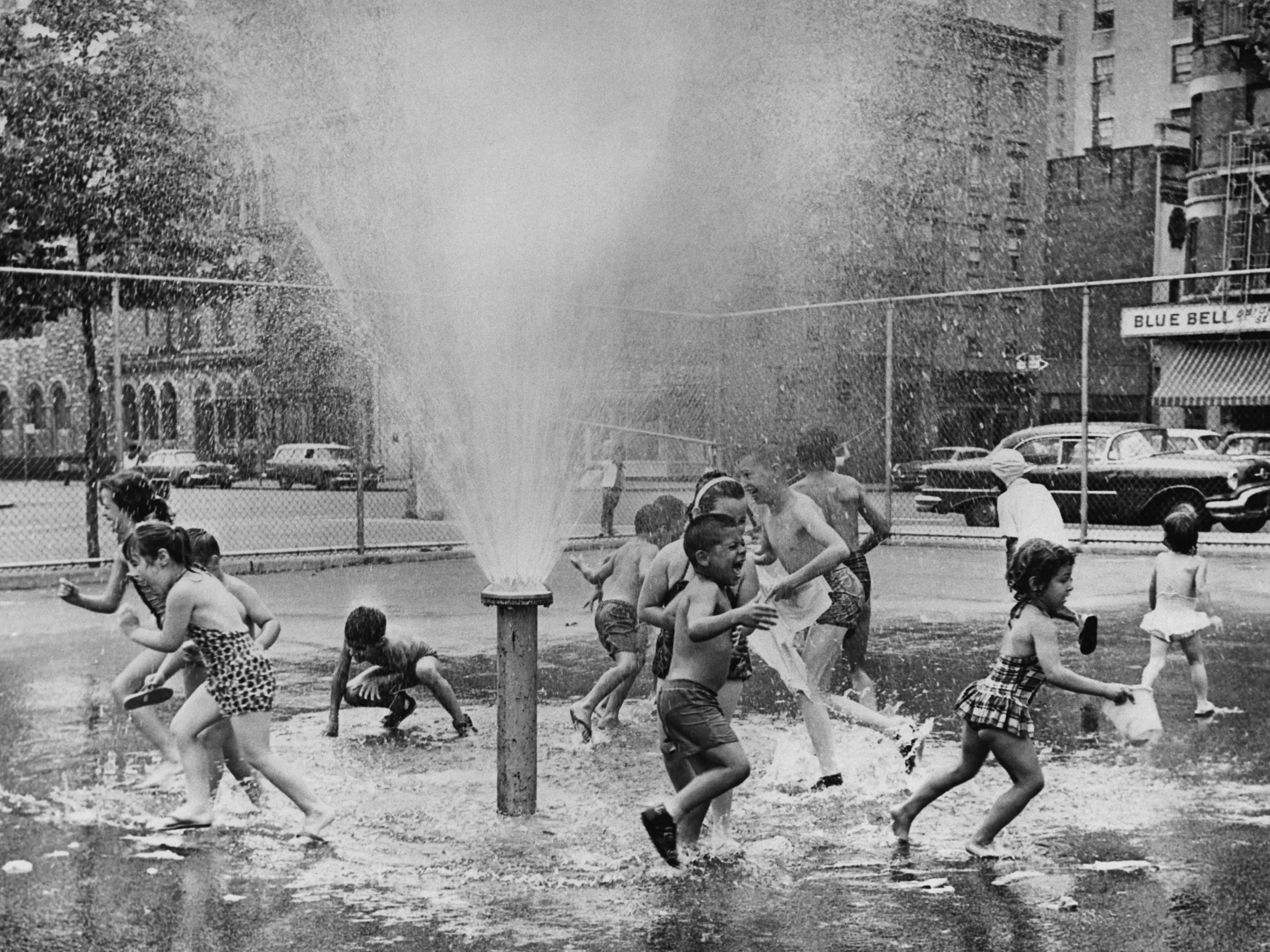 Children running around a fire hydrant