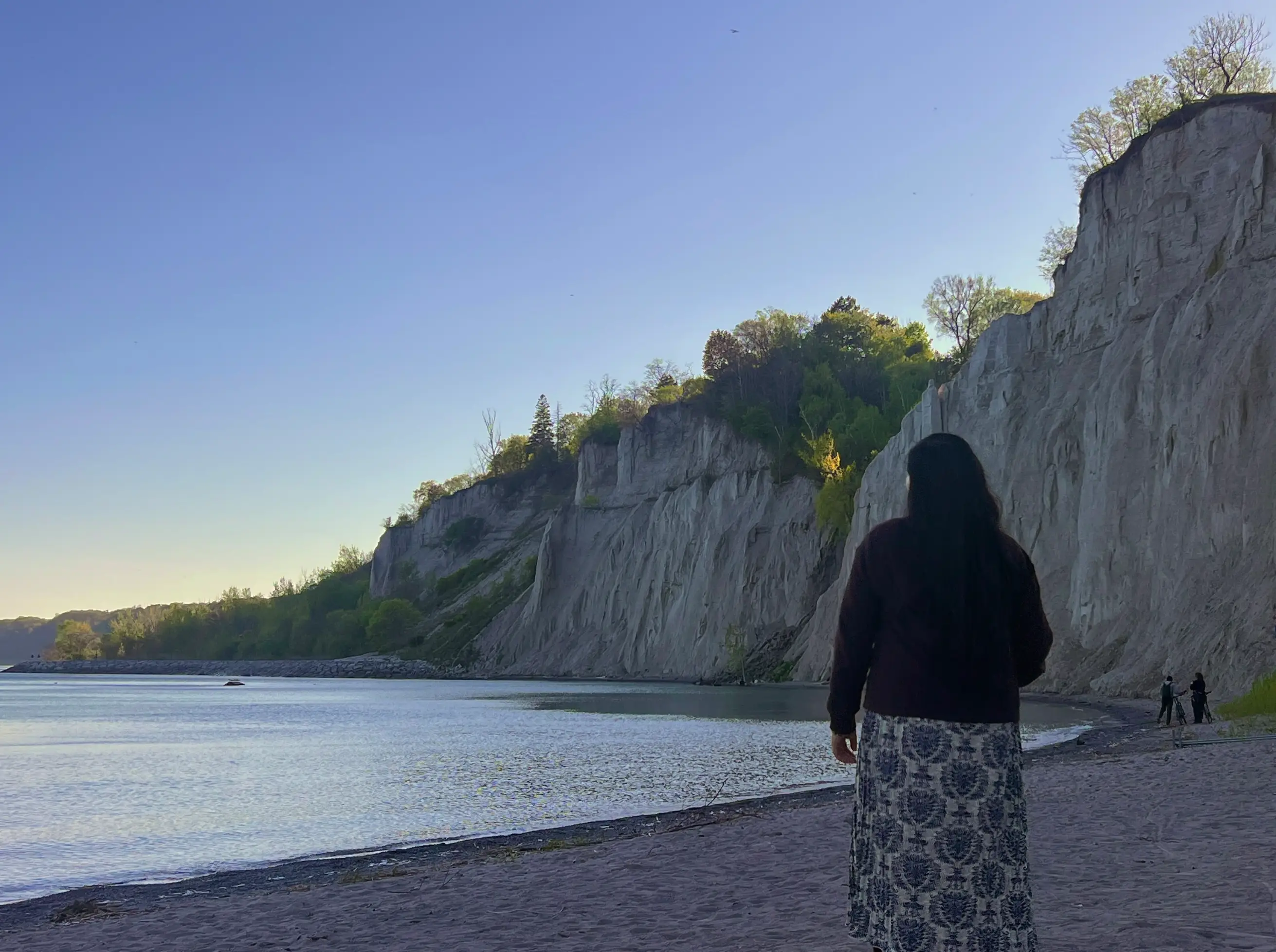 Woman on beach, alone, walkign in sand by water