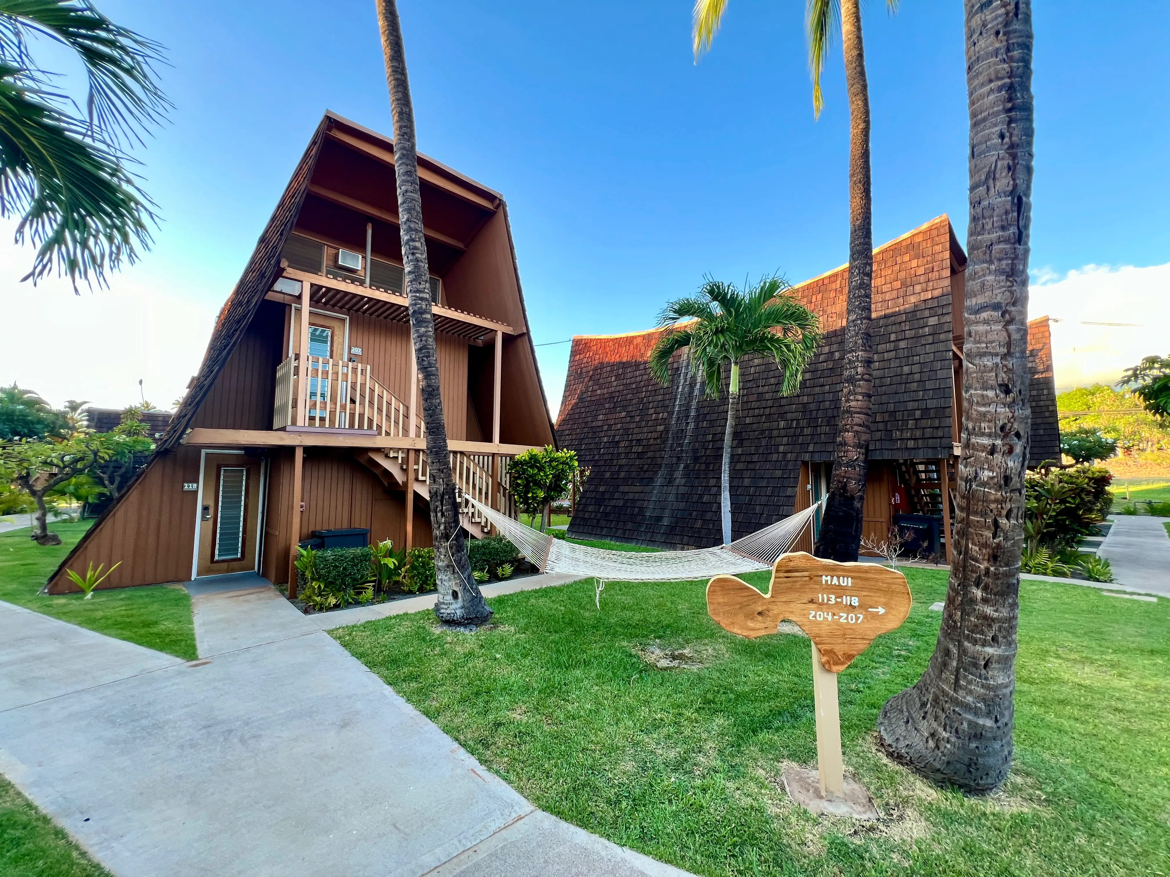 View of brown building next to hammock and palm trees