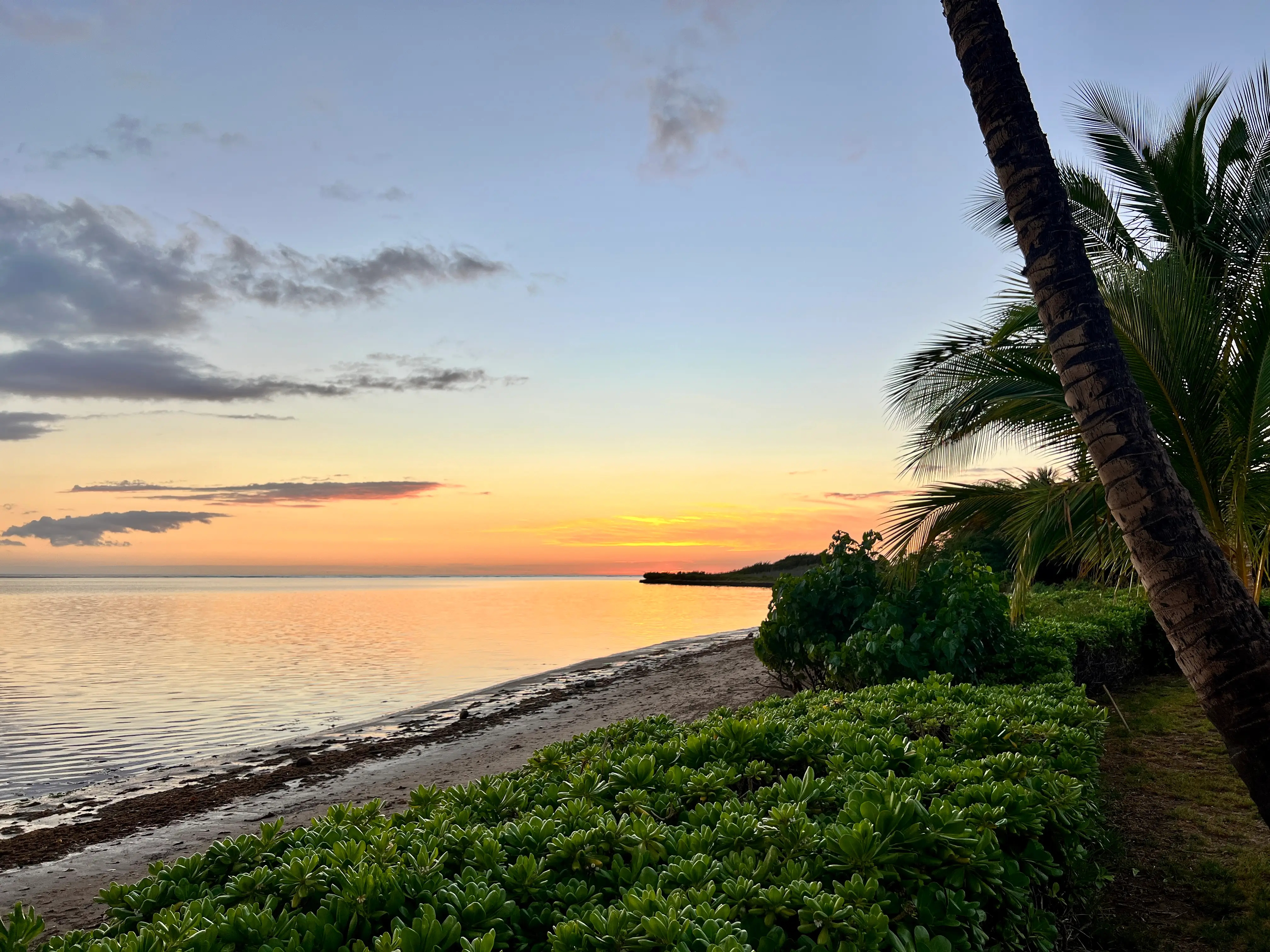 View of sunset over ocean on empty beach in Hawaii