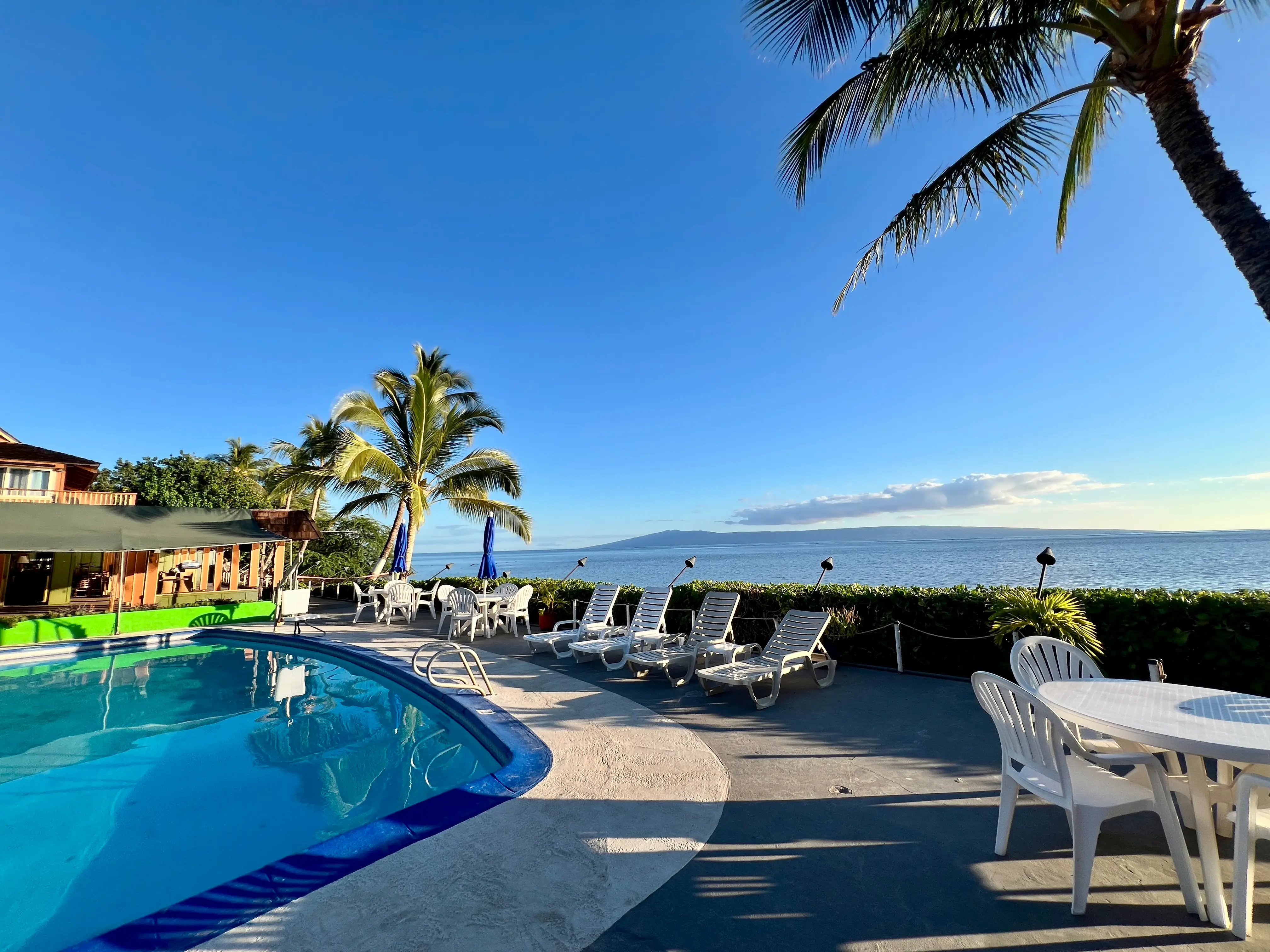 Pool with loungers and view of ocean nearby