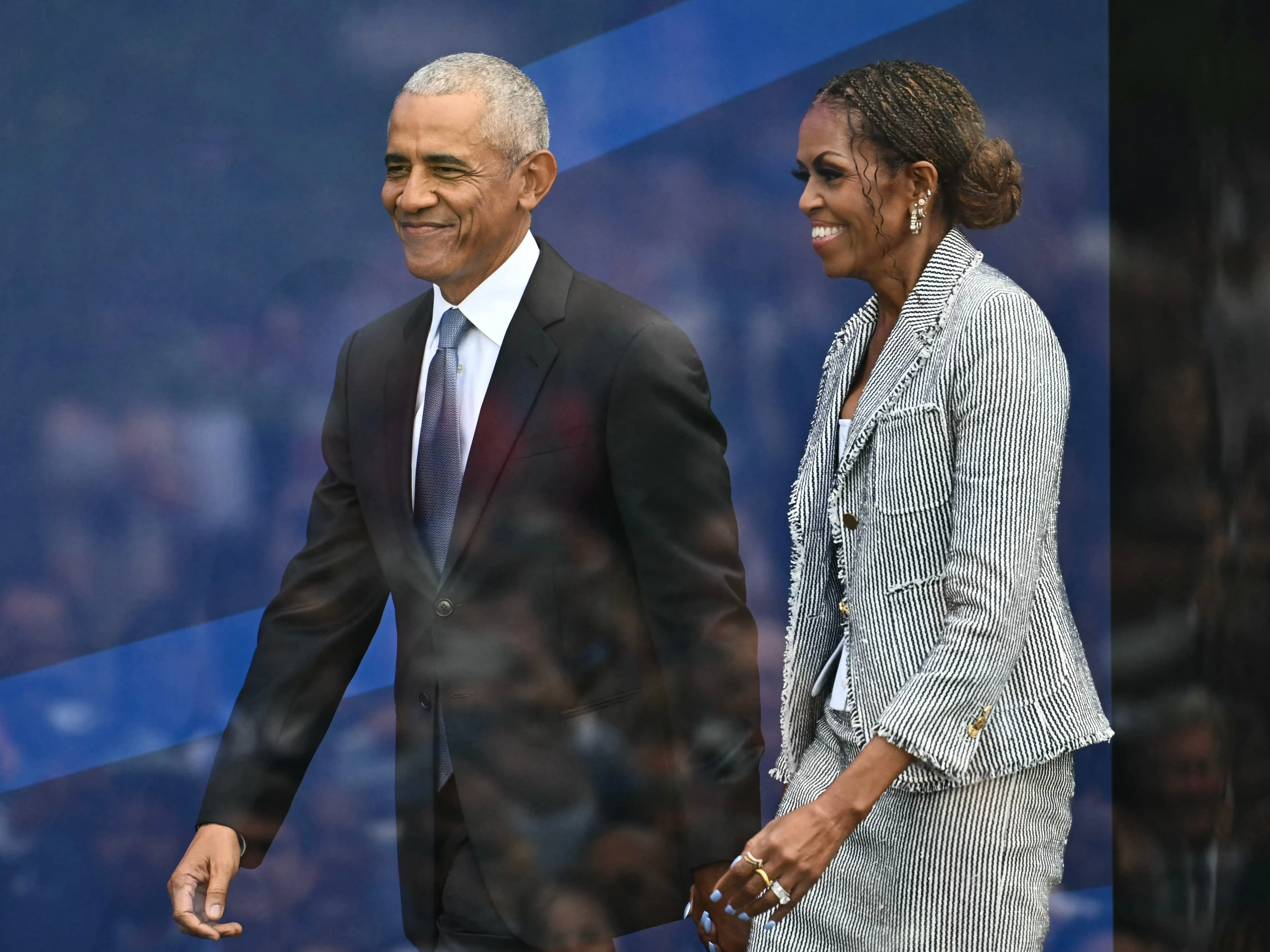 Michelle and Barack Obama walking hand in hand.