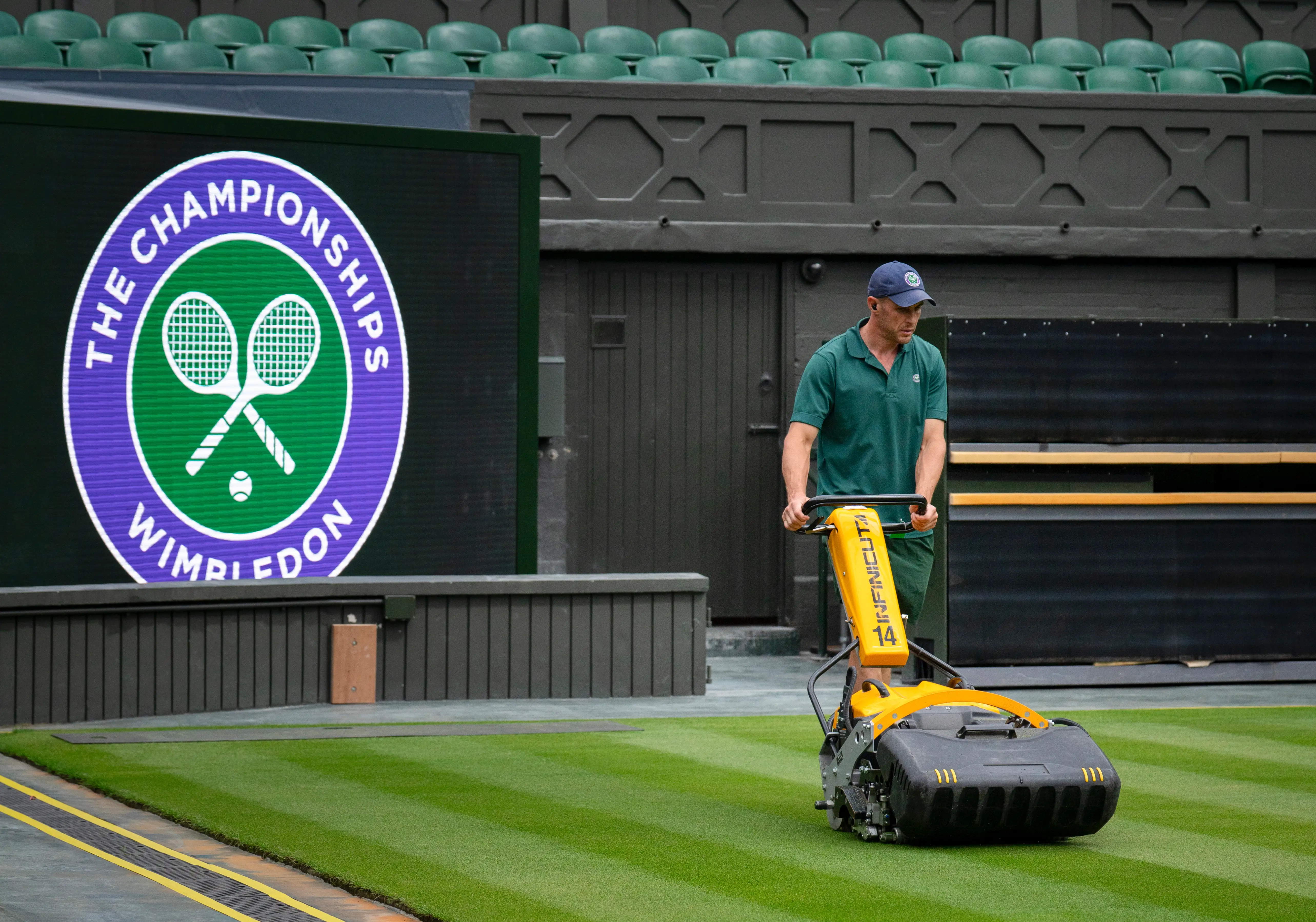 A groundskeeper mows the lawn on Centre Court.