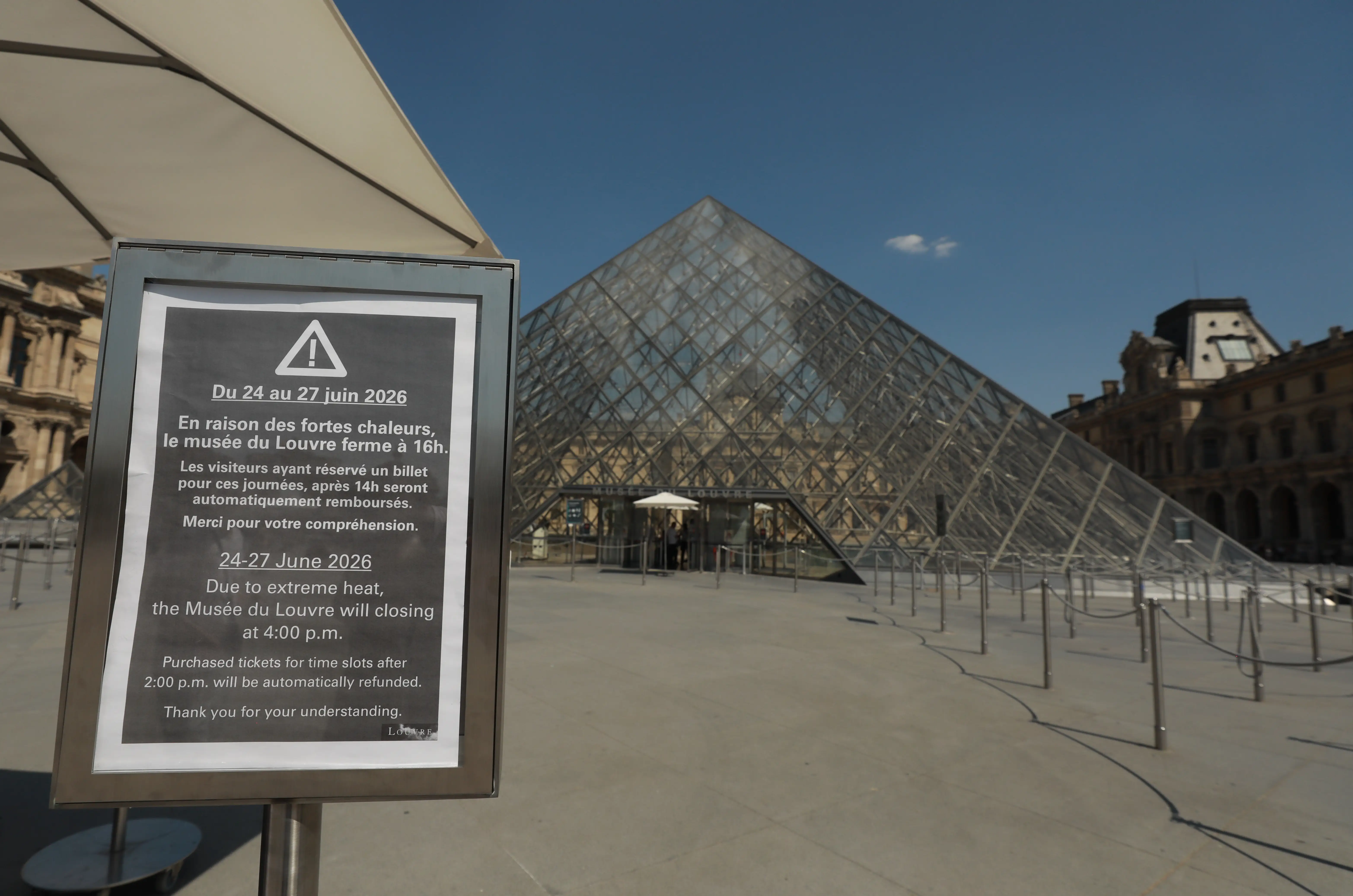 The Louvre Museum with a sign closing early in a heat wave.