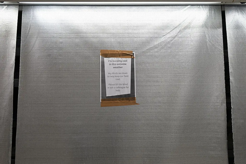 Blinds covering fridges in a supermarket in England.