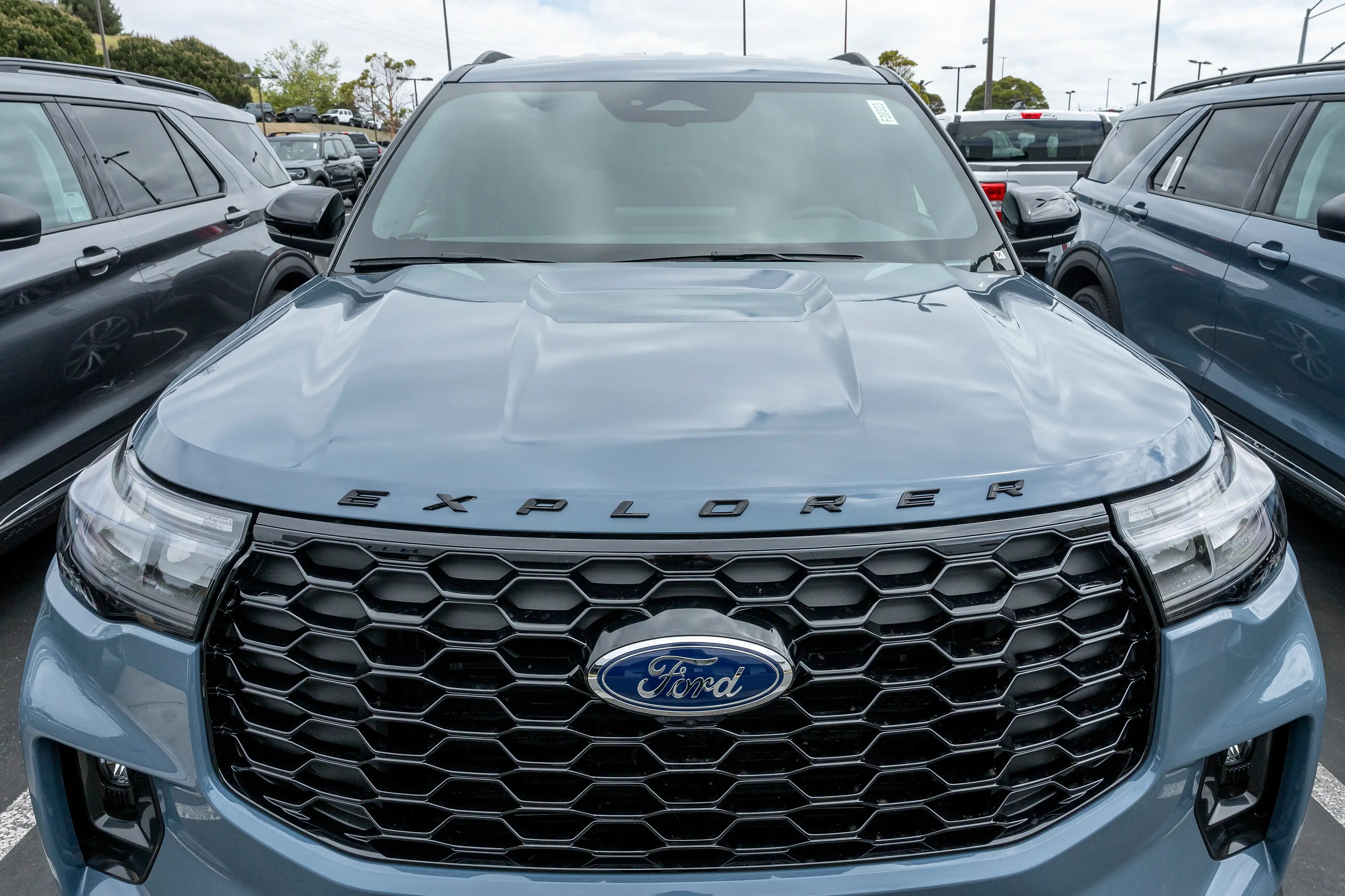 A blue Ford Explorer SUV is parked on a dealership lot.