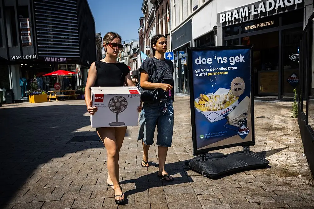 A woman holds a box with a fan in the Netherlands.