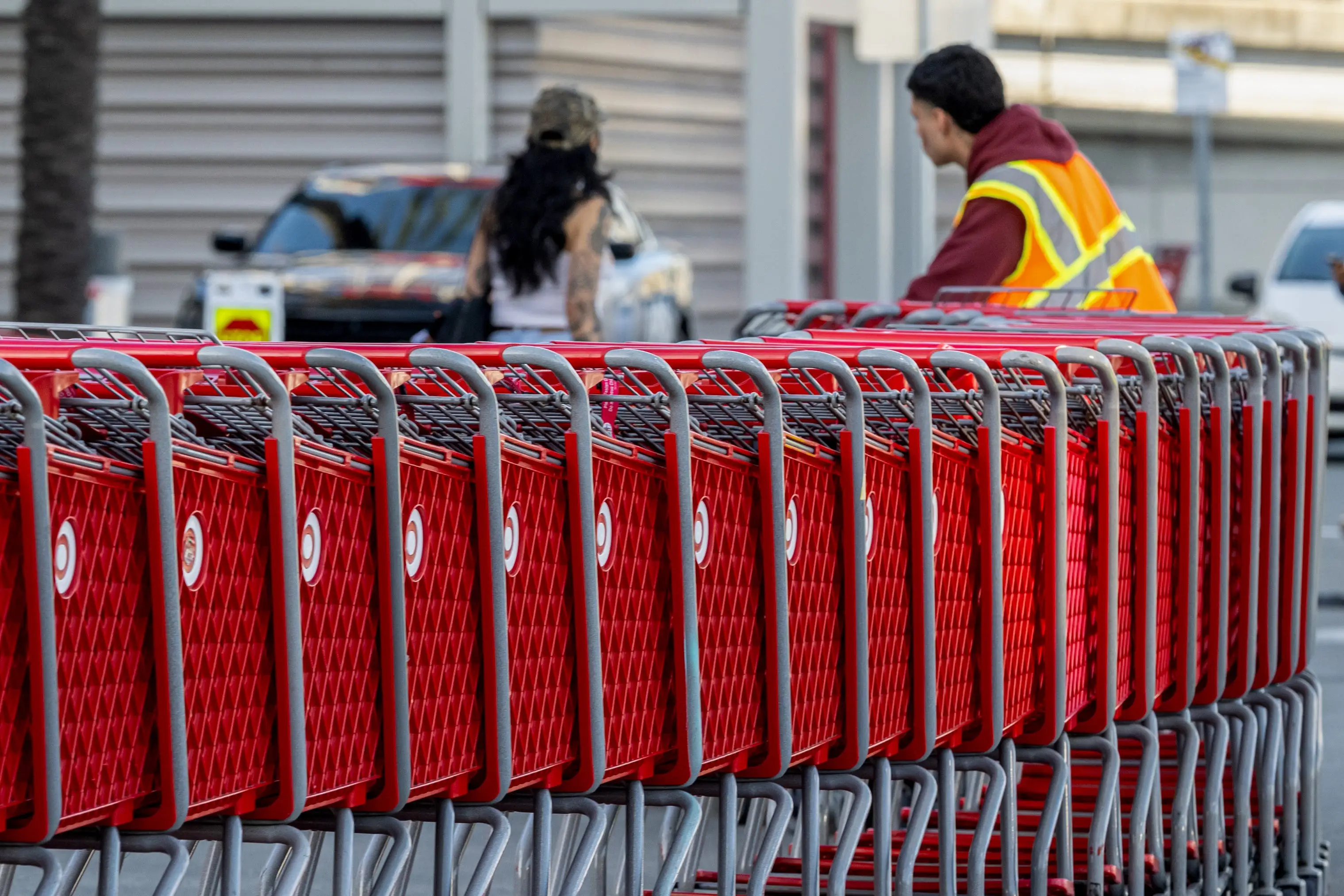 worker moves shopping carts outside a Target store in Emeryville, California, US.