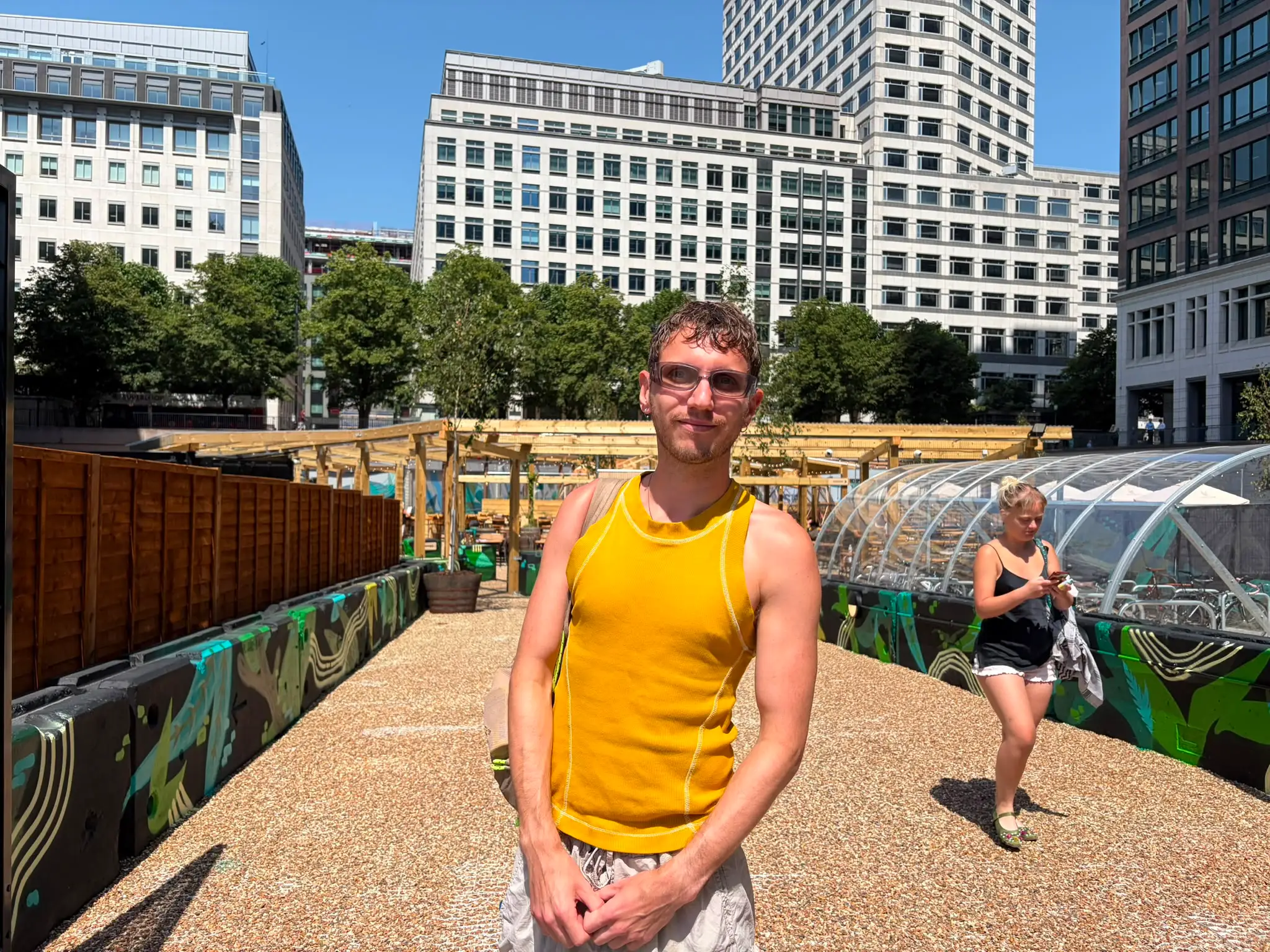 a man stands at the entrance to a pool deck with sunglasses on
