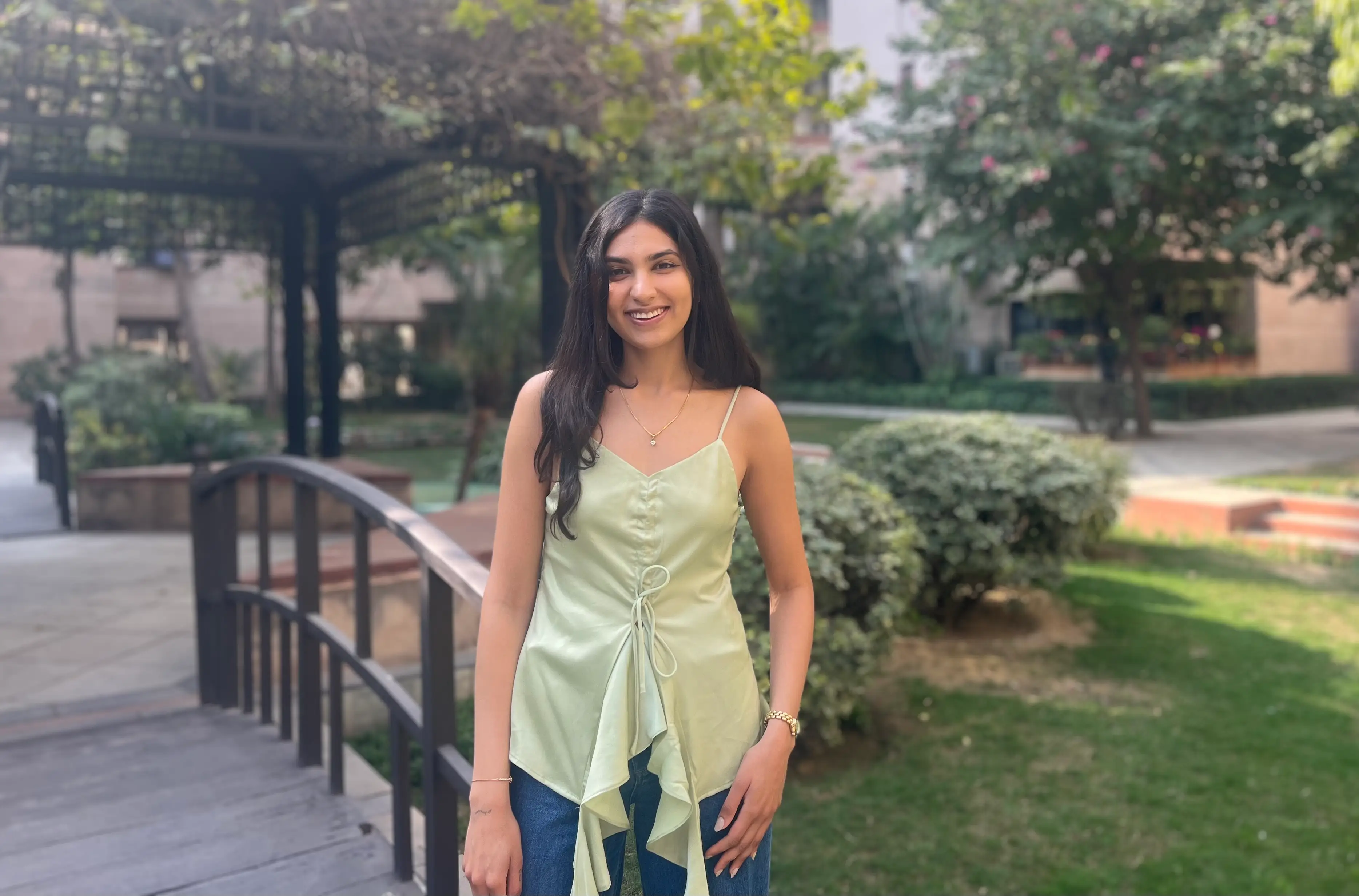 Nitya Kumar is wearing a green strappy top.
