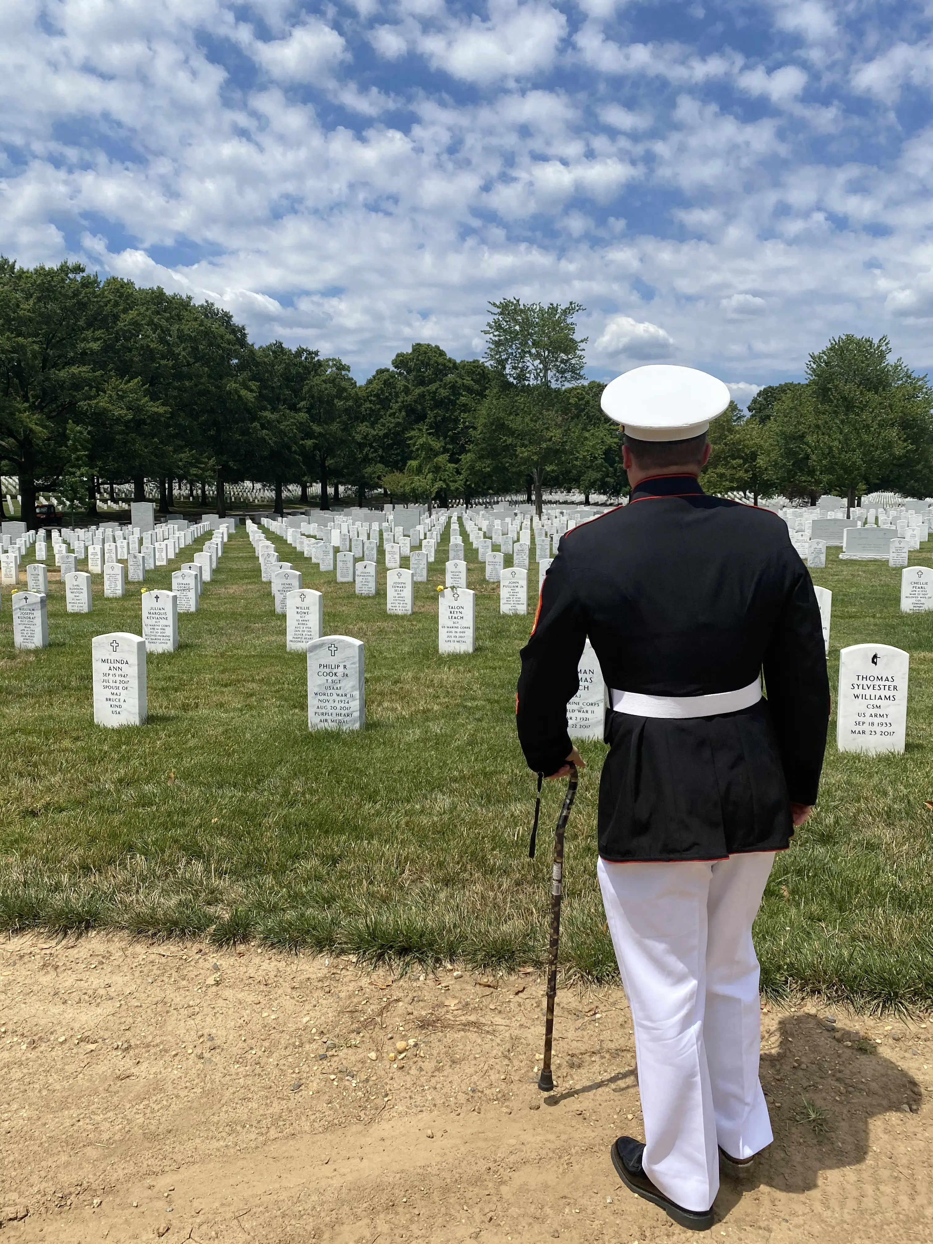 Nick Jones in uniform at cemetary with a cane.