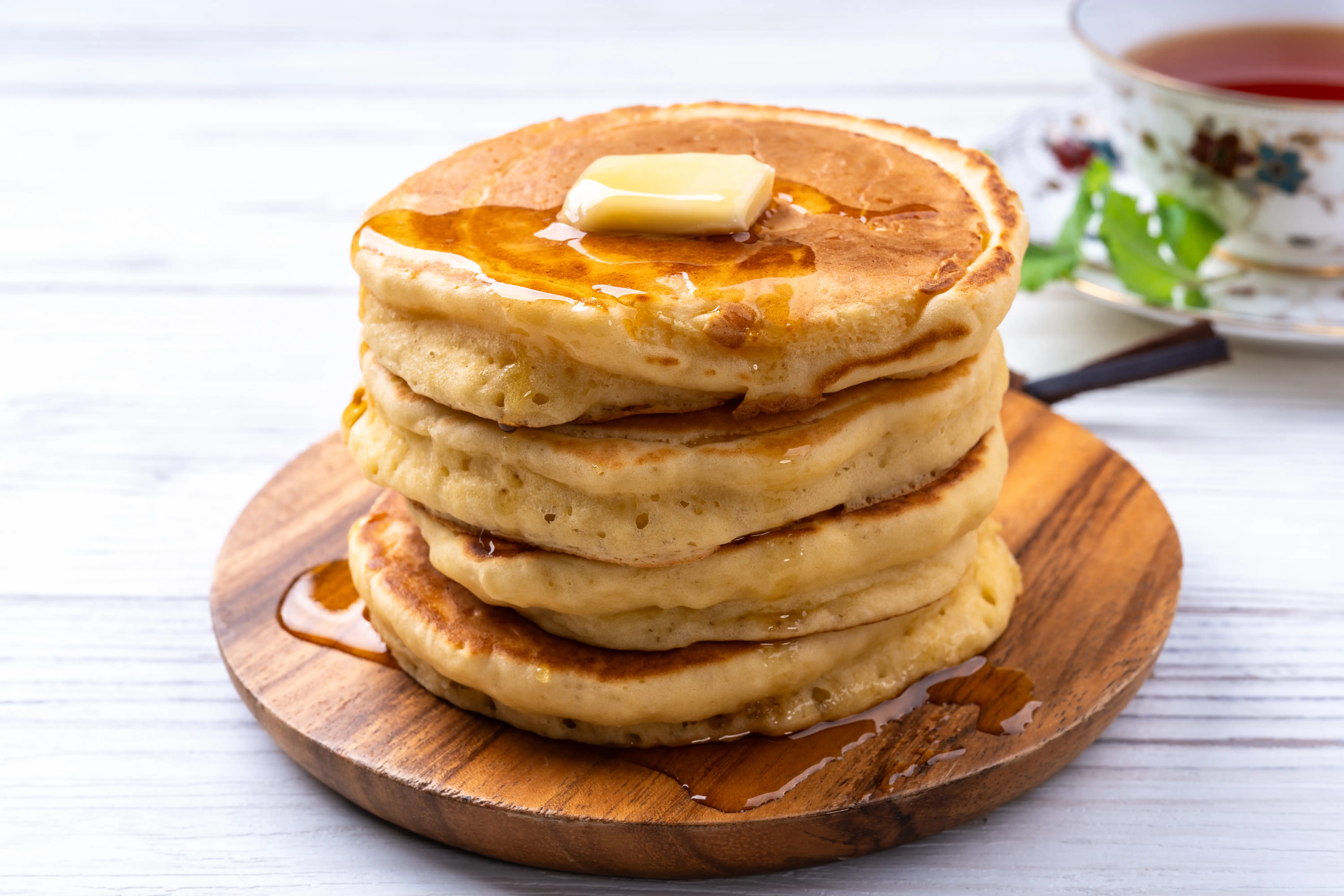 A stack of pancakes topped with butter.