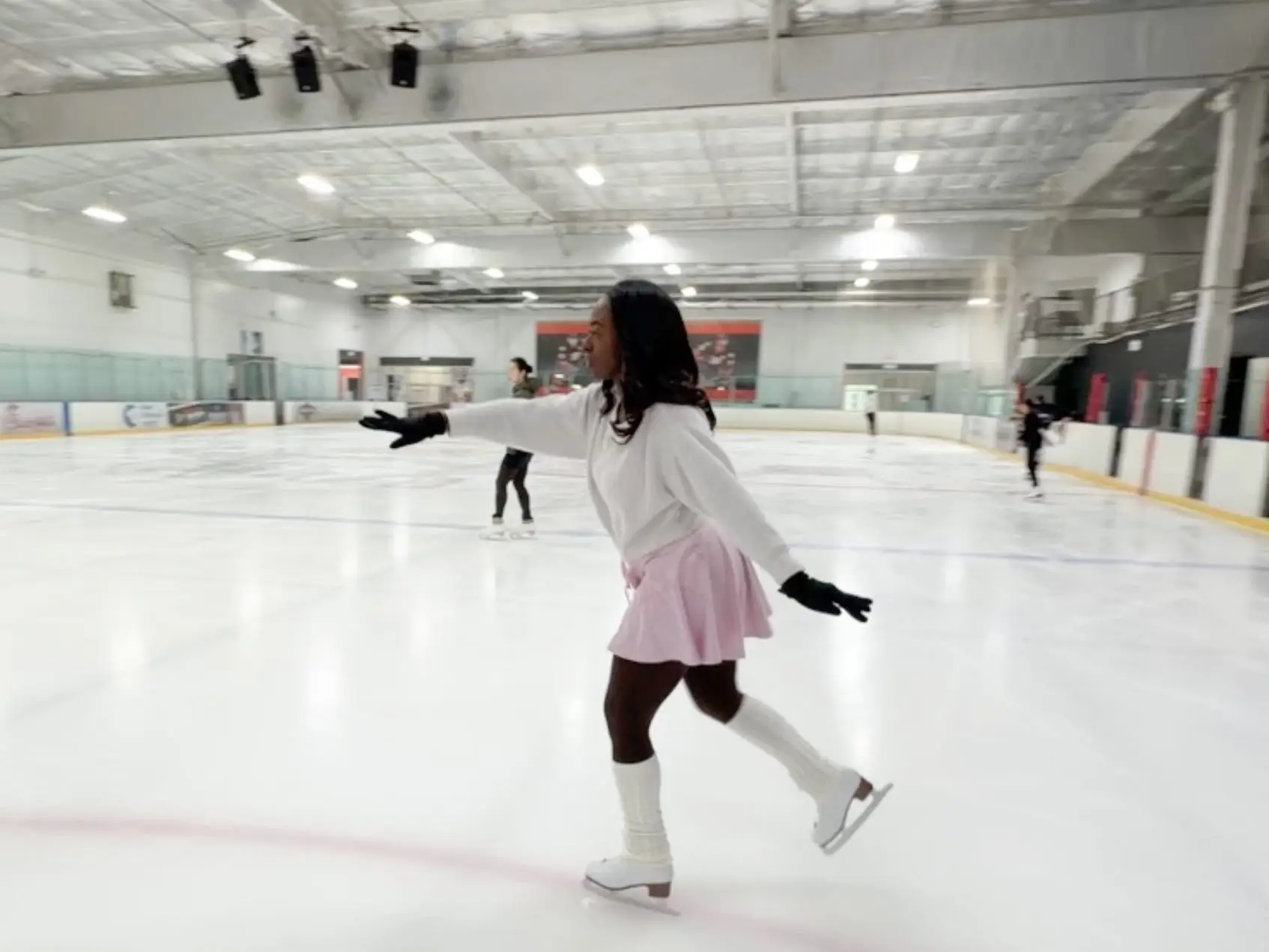 The writer gliding across an indoor ice skating rink.