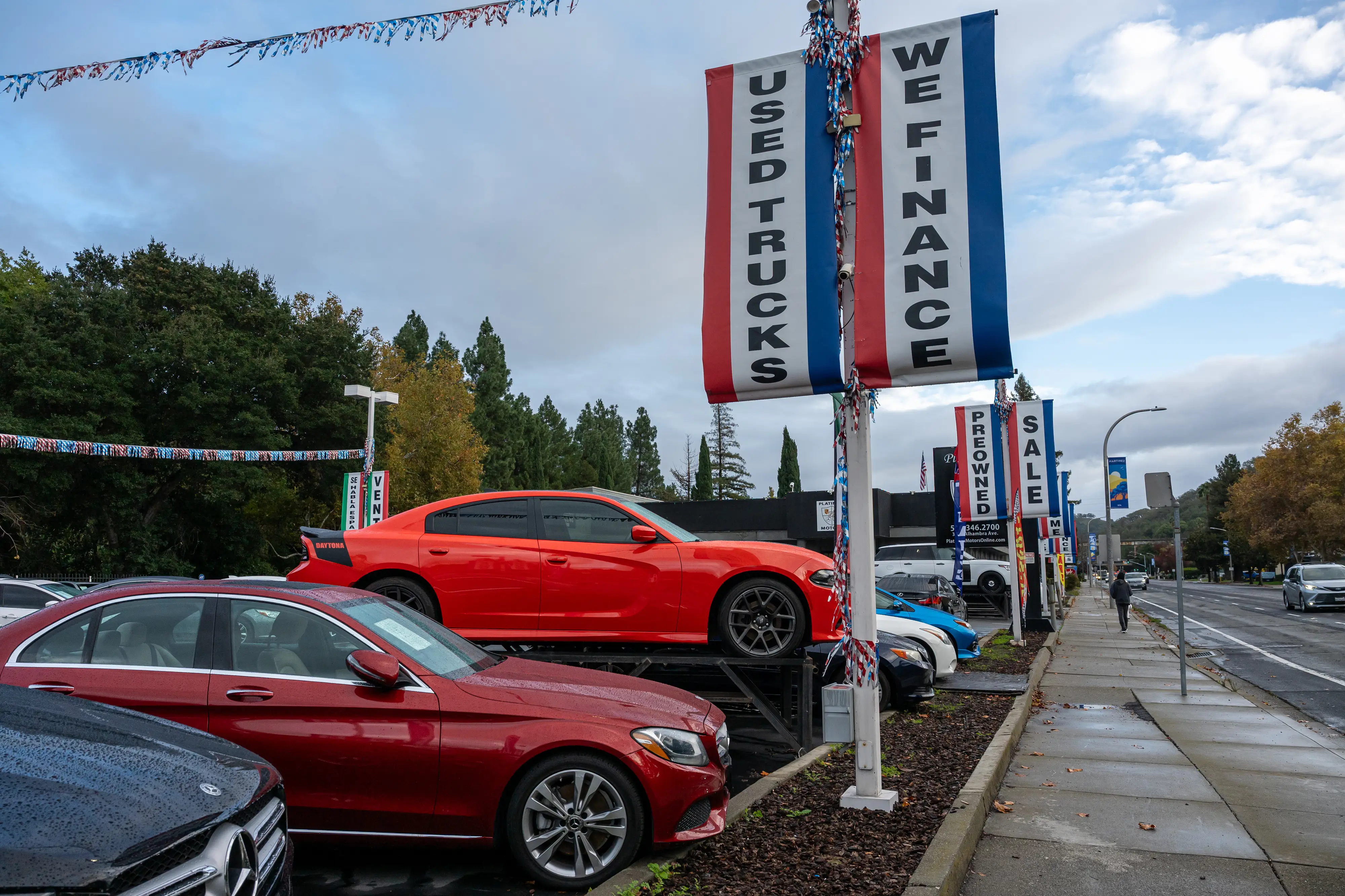 A used car dealership with flags hanging on light poles.