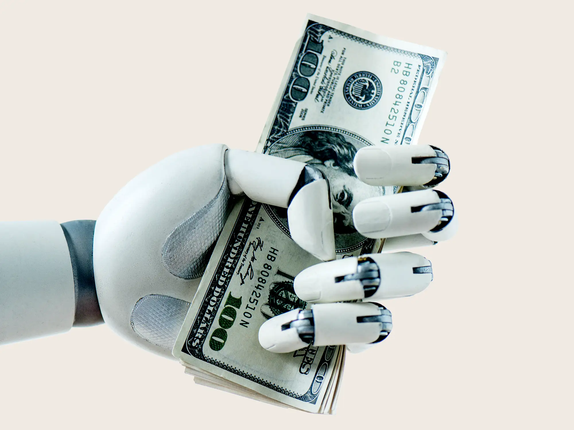 A robot hand grasps a stack of hundred-dollar bills