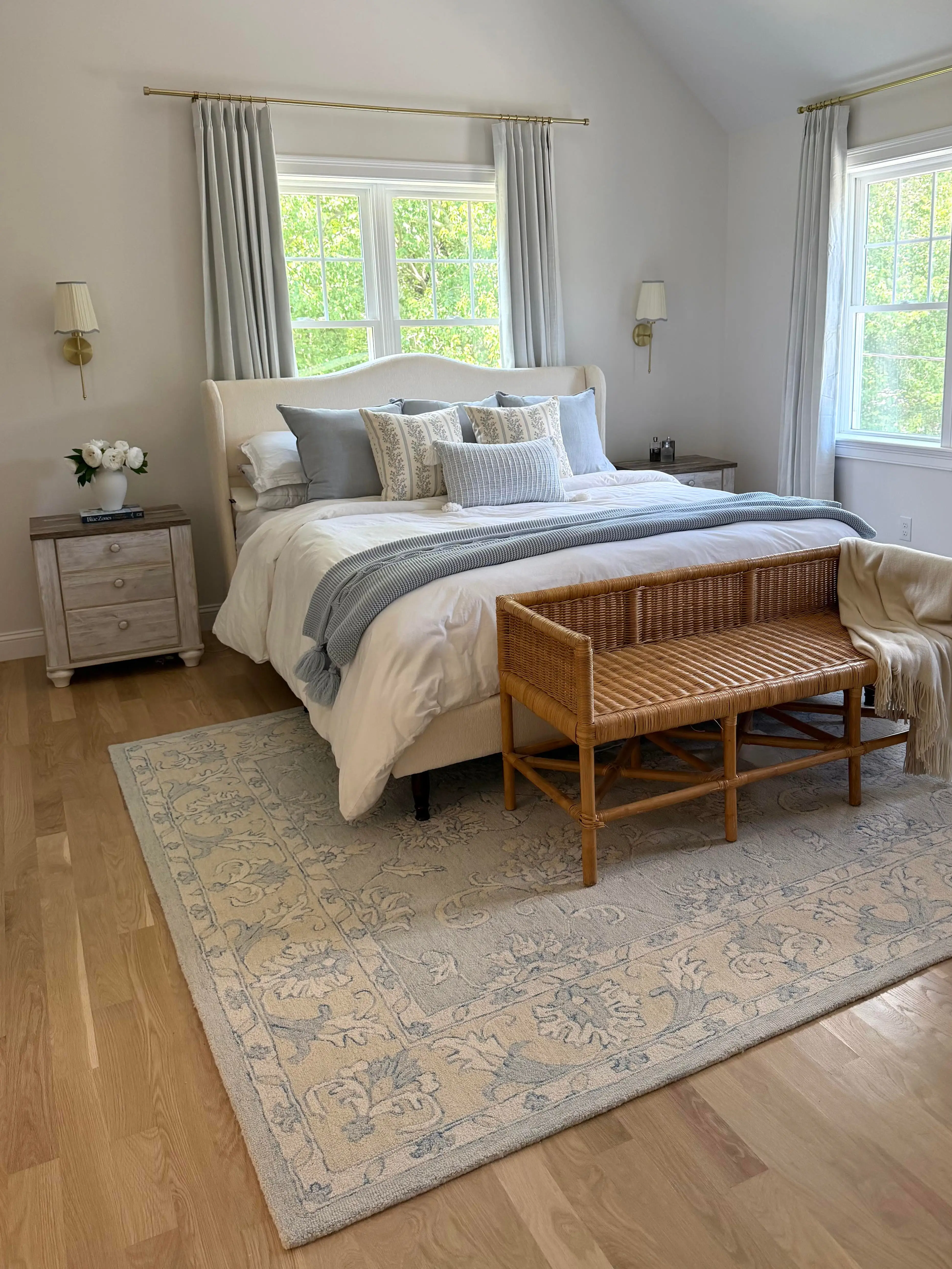 A bedroom with white walls, a high, vaulted ceiling, and bedroom furniture.