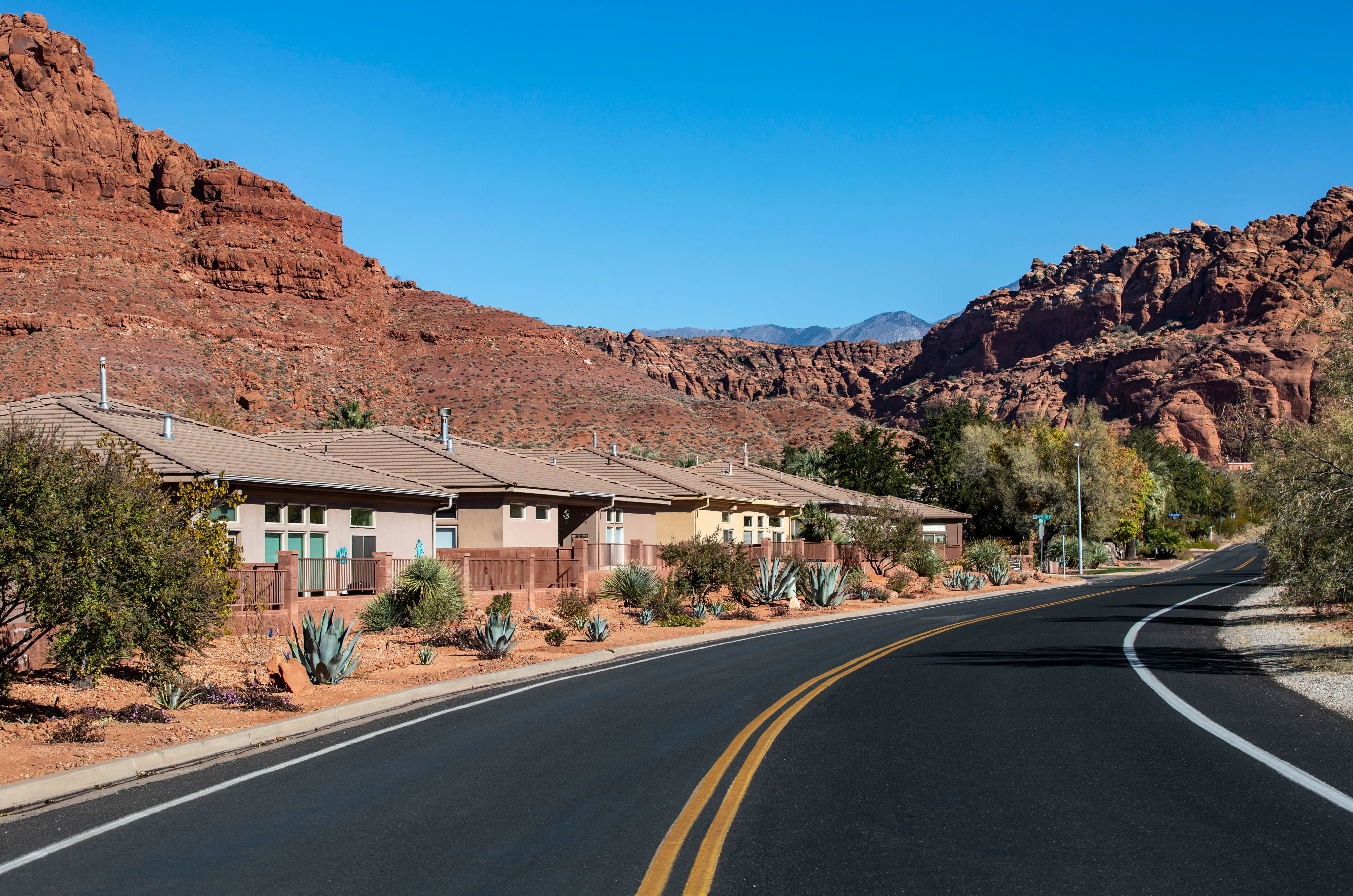 View of large rocks/sandstone behind houses near Snow Canyon State Park in Utah