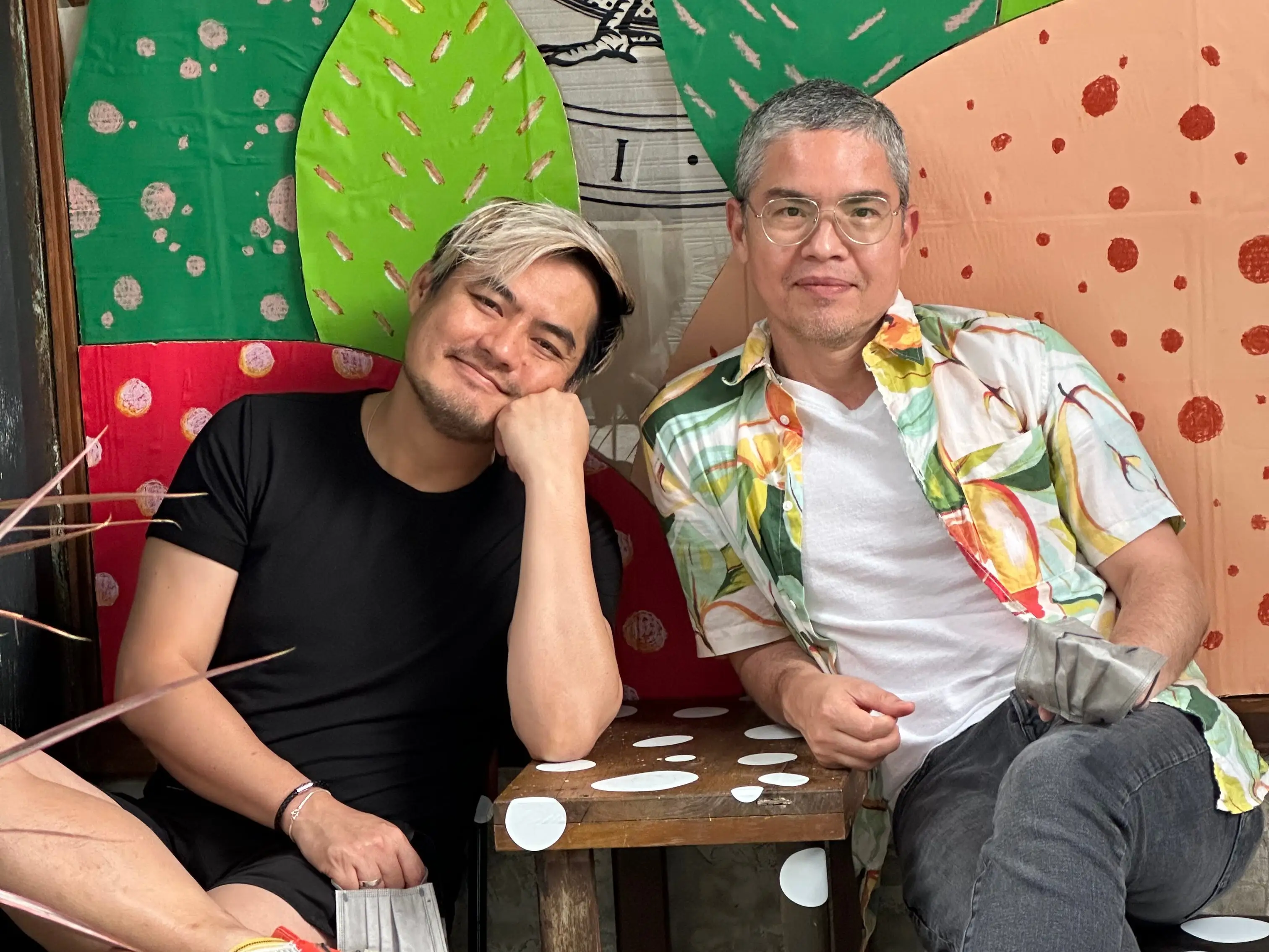 Two men seated at a restaurant in Bangkok.
