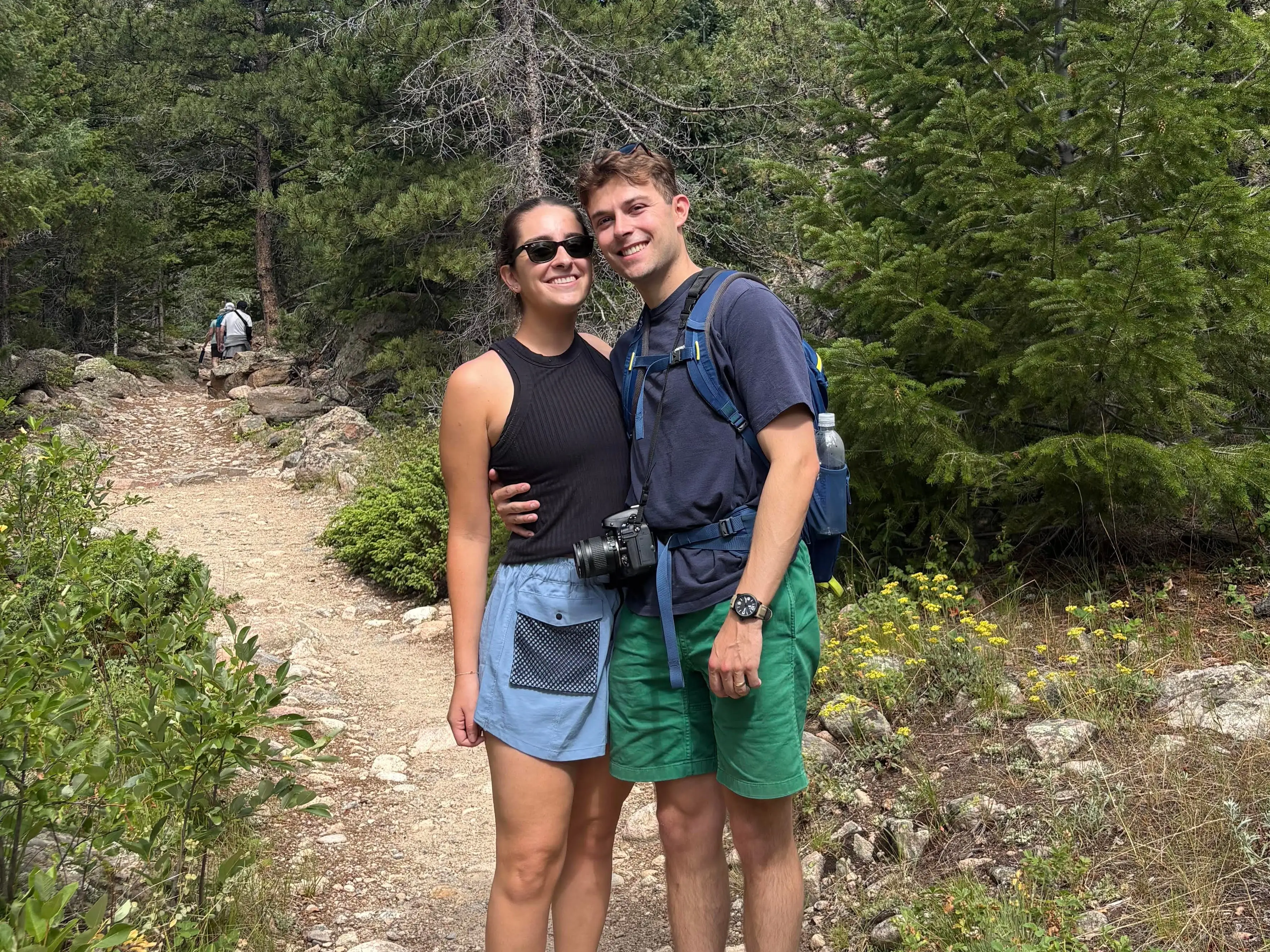 Matthew Russell and his wife are standing together on a hiking trail.
