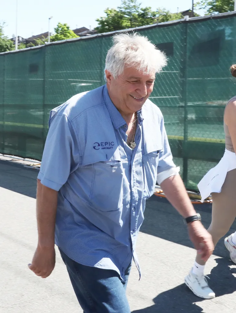 Giuseppe Oppedisano walking while smiling, wearing a light blue shirt with 
