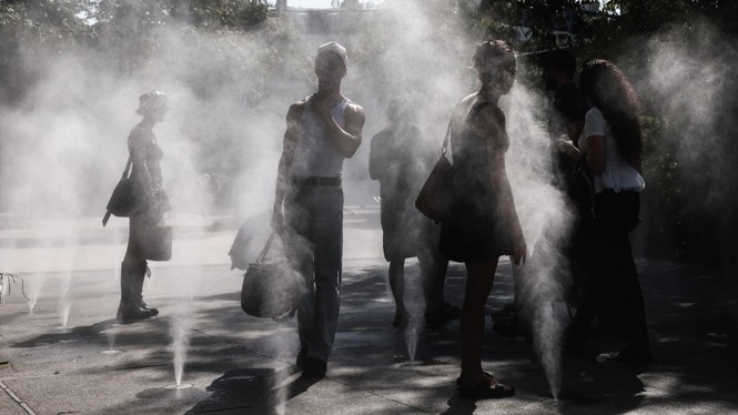 people stand in the mists of a cooling zone