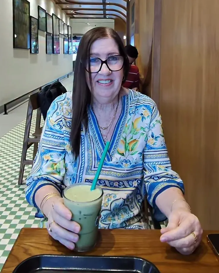 Jenny Slatten from 90 Day Fiancé smiles while holding a green drink with a straw.
