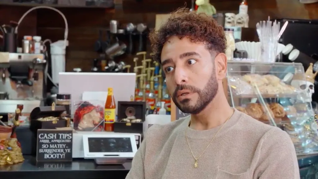 Mido looking shocked in a cafe.