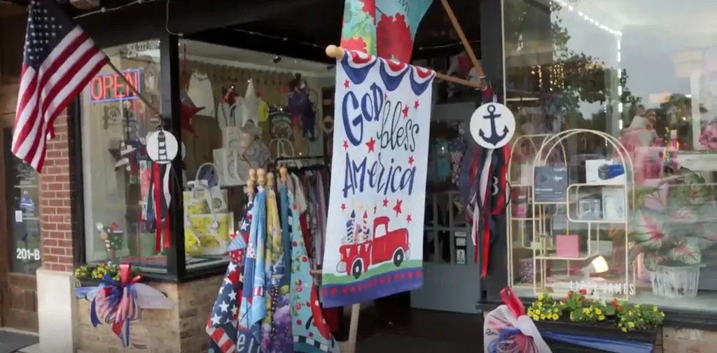 An outdoor storefront decorated with an American flag, a banner that says 