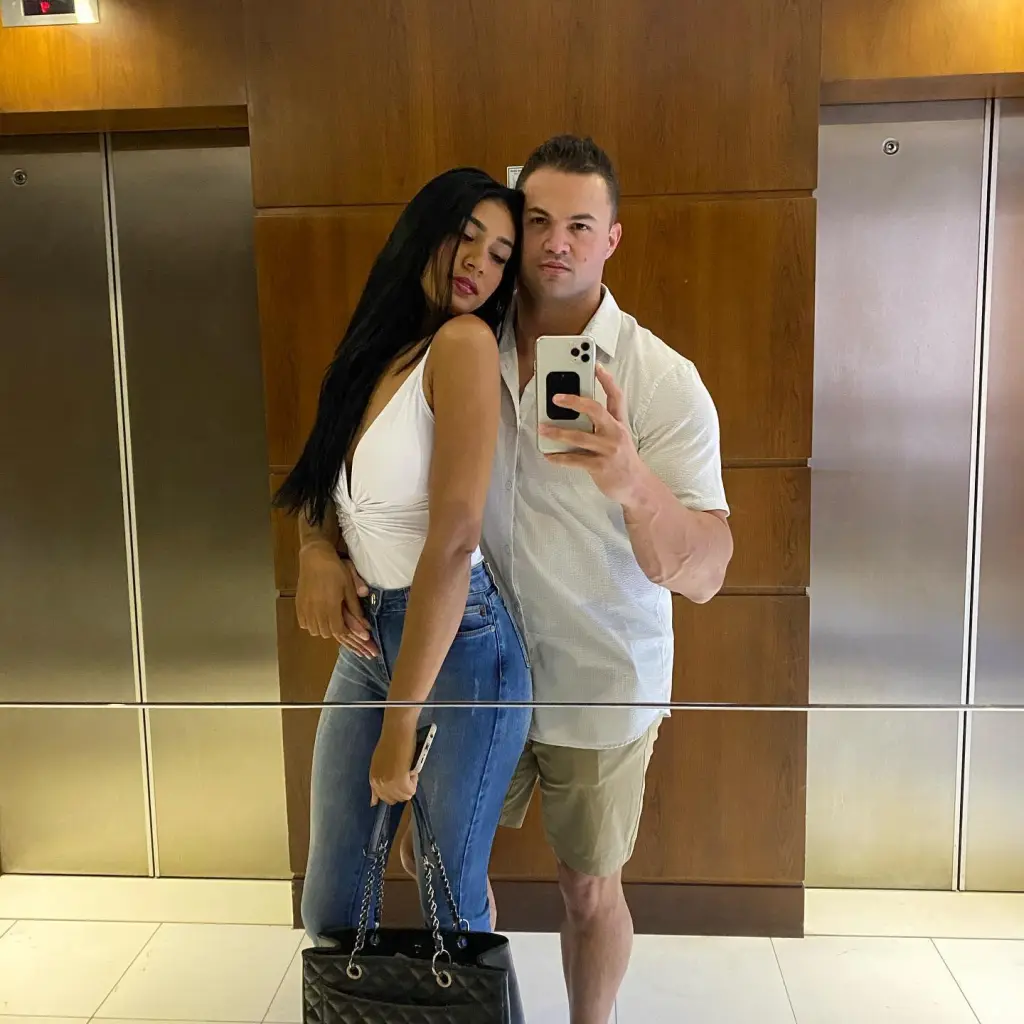 90 Day Fiance stars Patrick Mendes and Thais Ramone posing for a selfie in front of an elevator.