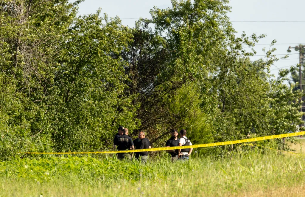 Bates County coroner officers investigate near the scene of a fatal skydiving plane crash near Butler Memorial Airport in Butler, Missouri.