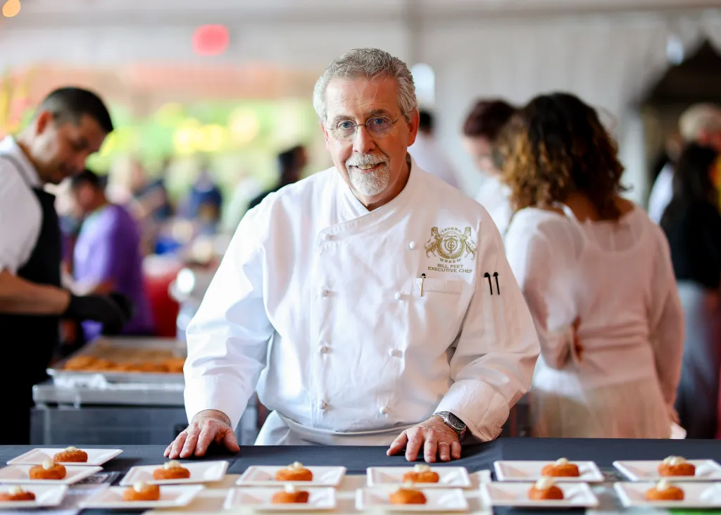 Chef Bill Peet from Tavern on the Green standing behind a table of small appetizers.