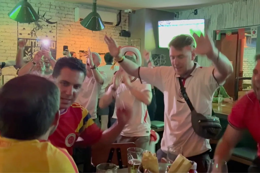 Soccer fans celebrating in a bar.