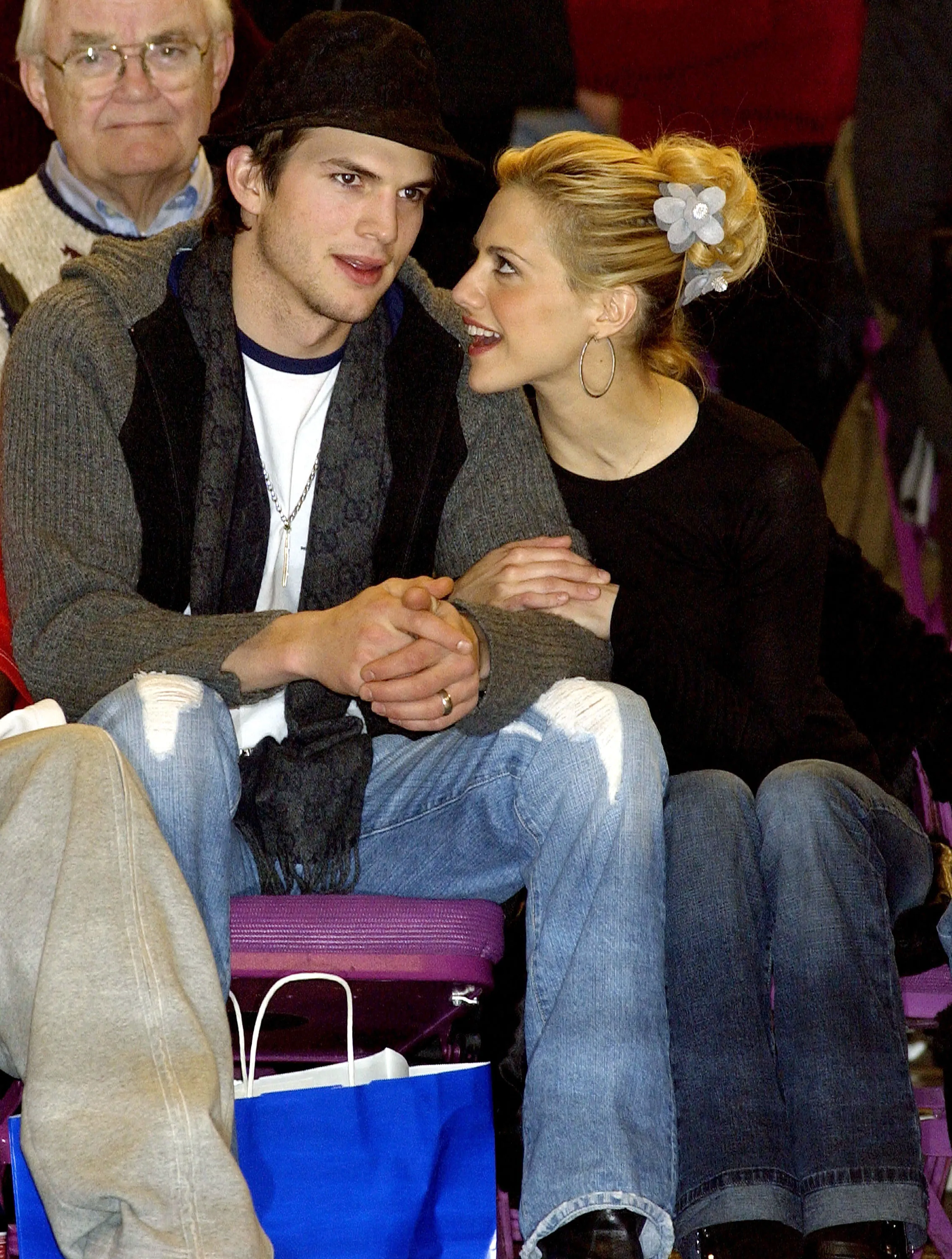 Brittany Murphy (R) sits with boyfriend/actor Ashton Kutcher (L) at the New York Knicks vs. San Antonio Spurs basketball game December 30, 2002