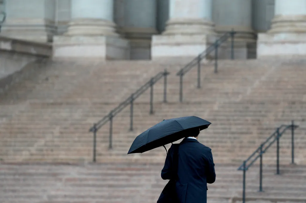 A person uses an umbrella to stay dry in the rain outside the state Capitol in Oklahoma City, Tuesday, June 23, 2026.