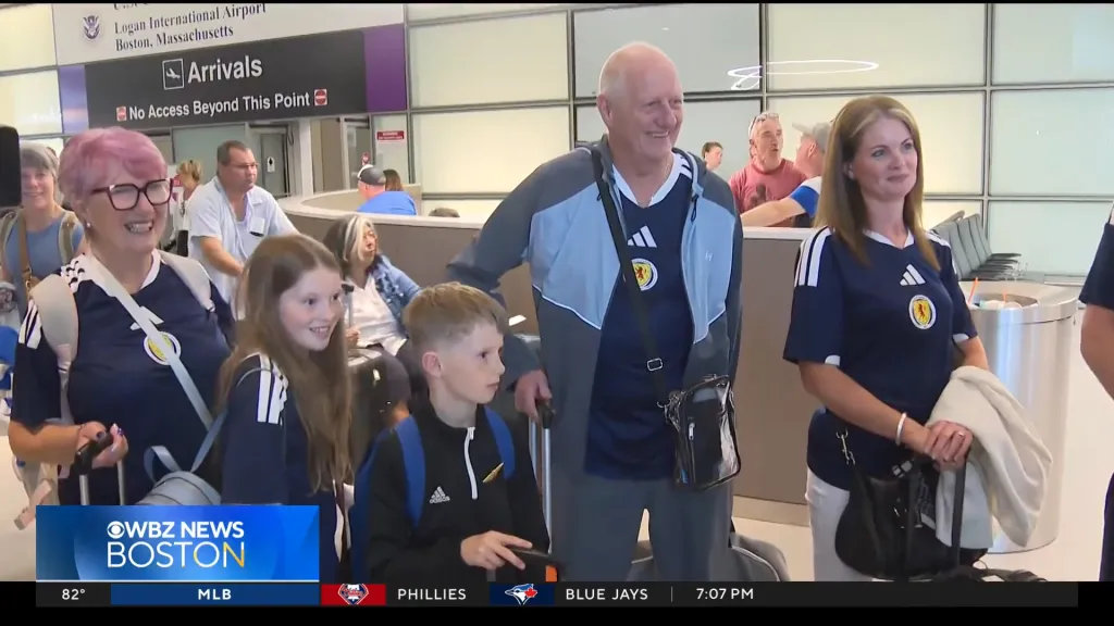 A family wearing Scottish football shirts at Boston Logan International Airport.