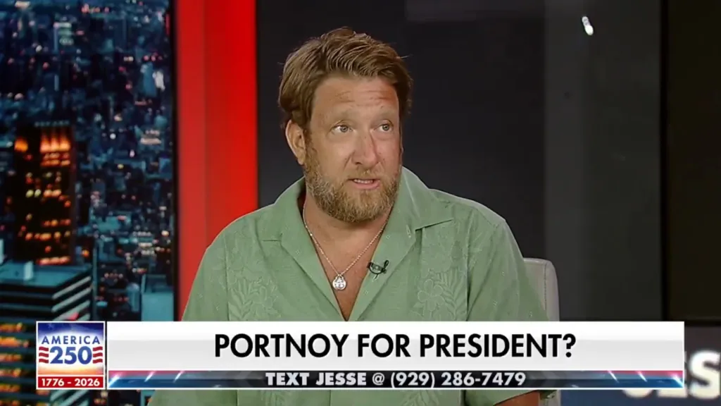 A man with a beard and light green shirt in a news interview, with the text 