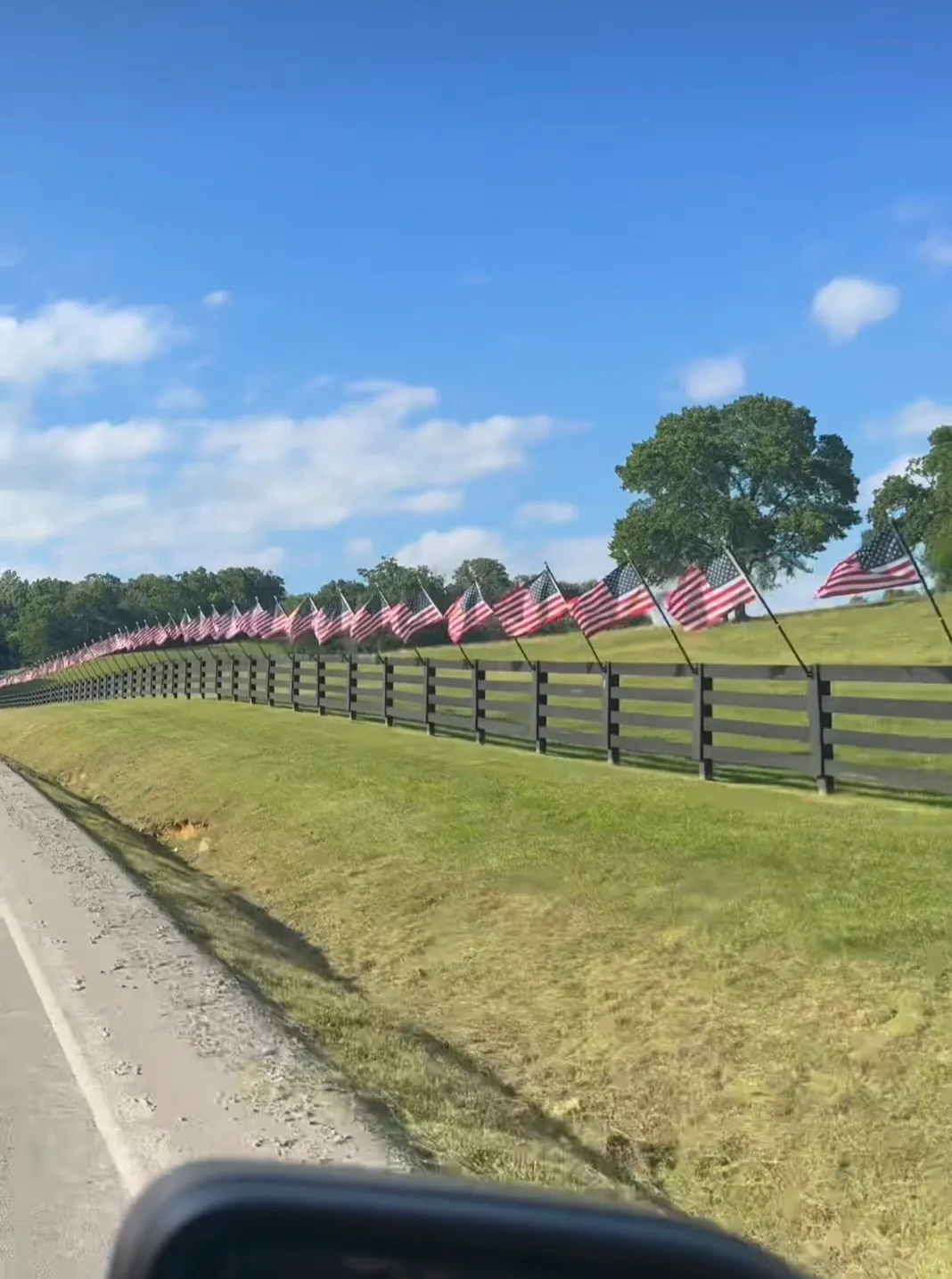 Carrie Underwood took to Instagram to share a video of her driving past a large fence adorned with American flags throughout the length of the property.