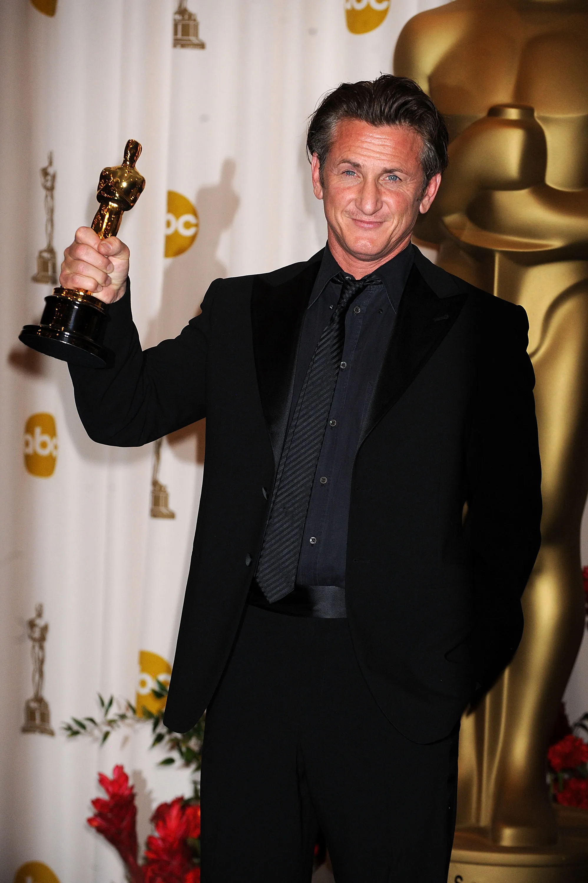Actor Sean Penn holding an Oscar statuette.