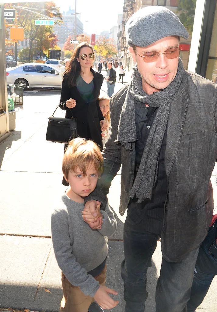 Angelina Jolie, Brad Pitt, Knox Jolie-Pitt, and Vivienne Jolie-Pitt walk down a city street.