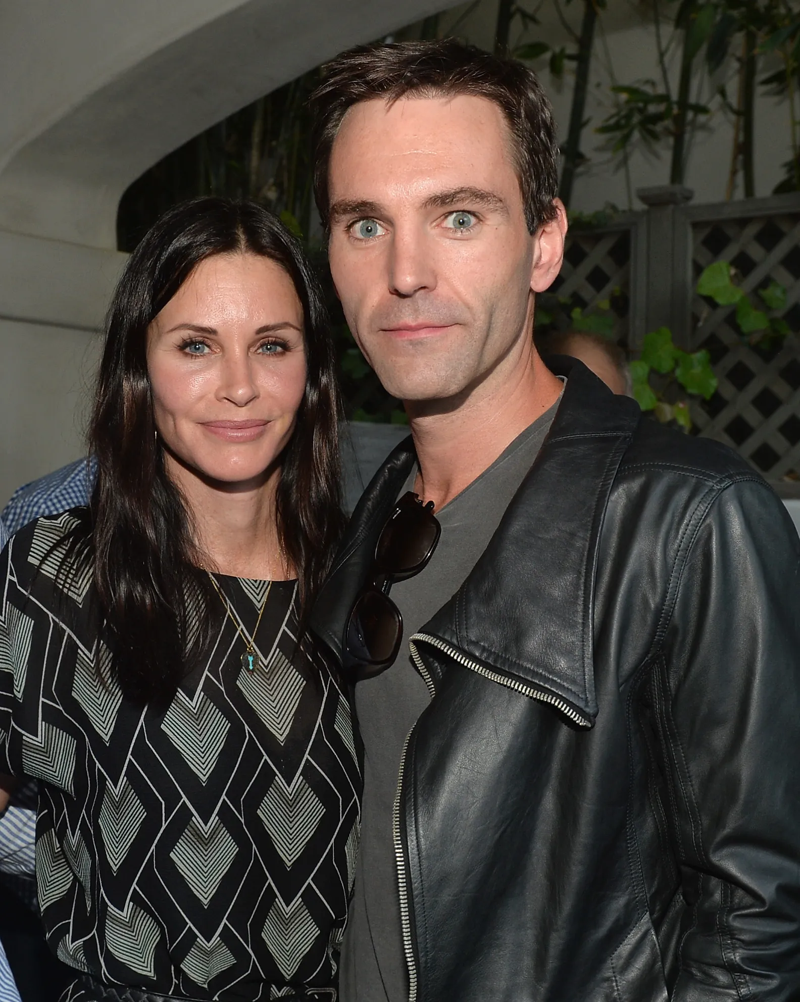 Courteney Cox and Johnny McDaid posing at a book release party.