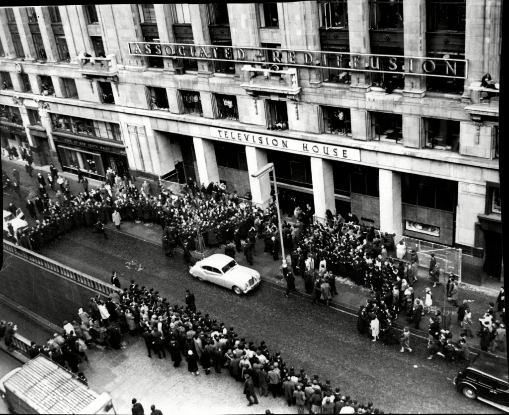 Aerial view of The Beatles arriving at Television House, Kingsway, surrounded by fans and police.