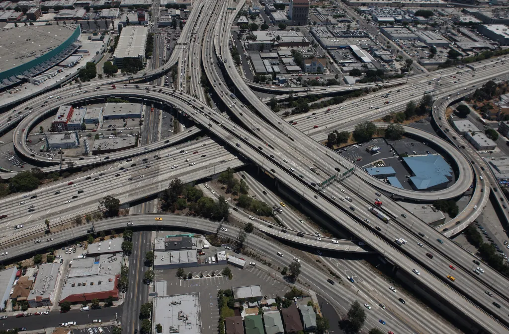 Aerial view of a complex highway interchange in Los Angeles with multiple intersecting roads filled with cars.