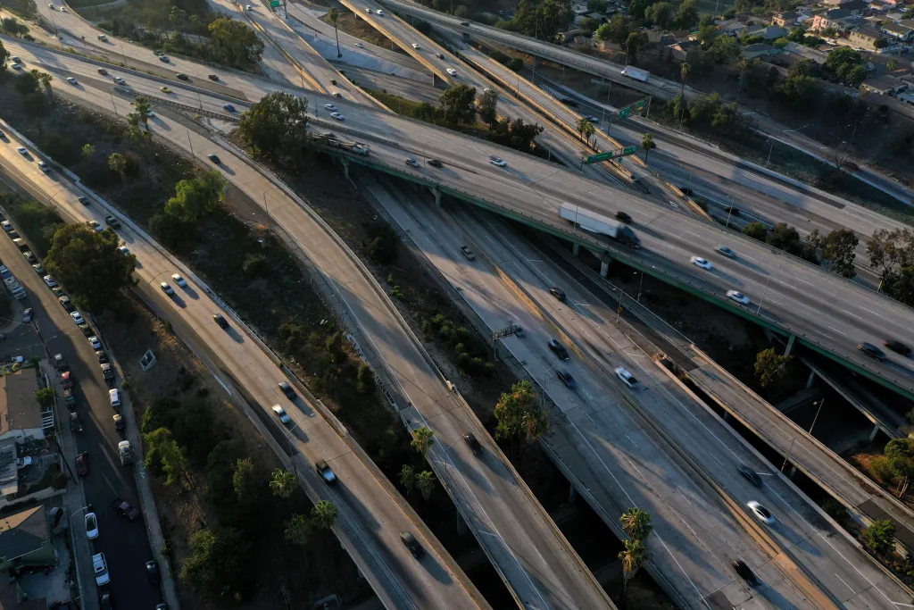Aerial view of the East Los Angeles Interchange complex, showing multiple freeway levels with cars in motion.