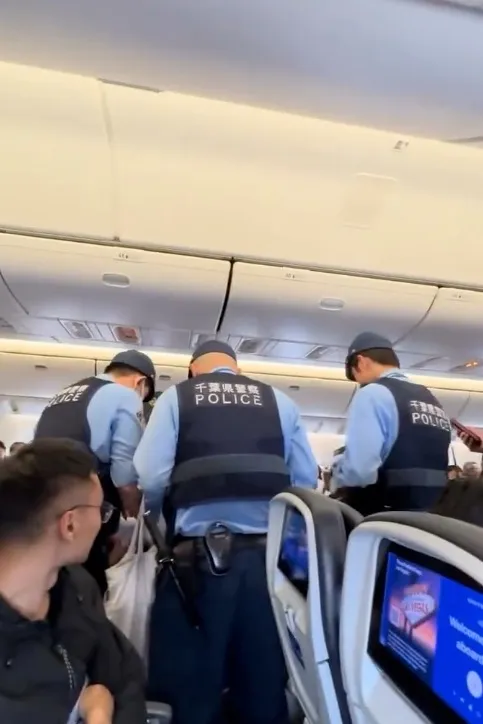 Police officers inside an airplane following a collision.