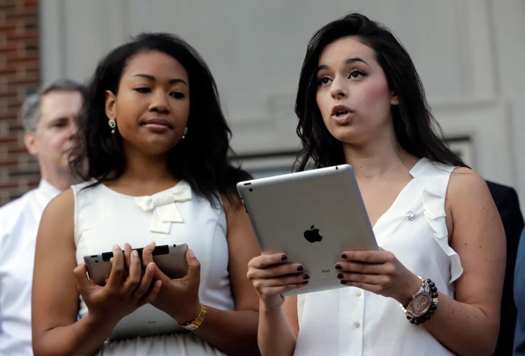 University of Alabama students Yardena Wolf and Khortlan Patterson hold tablets while speaking at a protest against the university's segregated sorority system.